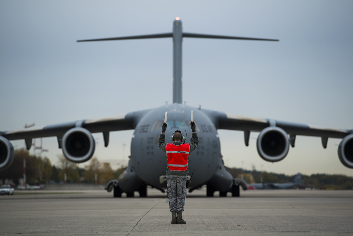 A crew chief marshals an Air Force C-17 Globemaster III on Ramstein Air Base, Germany Oct. 31, 2018. (Senior Airman Devin M. Rumbaugh/Air Force)
