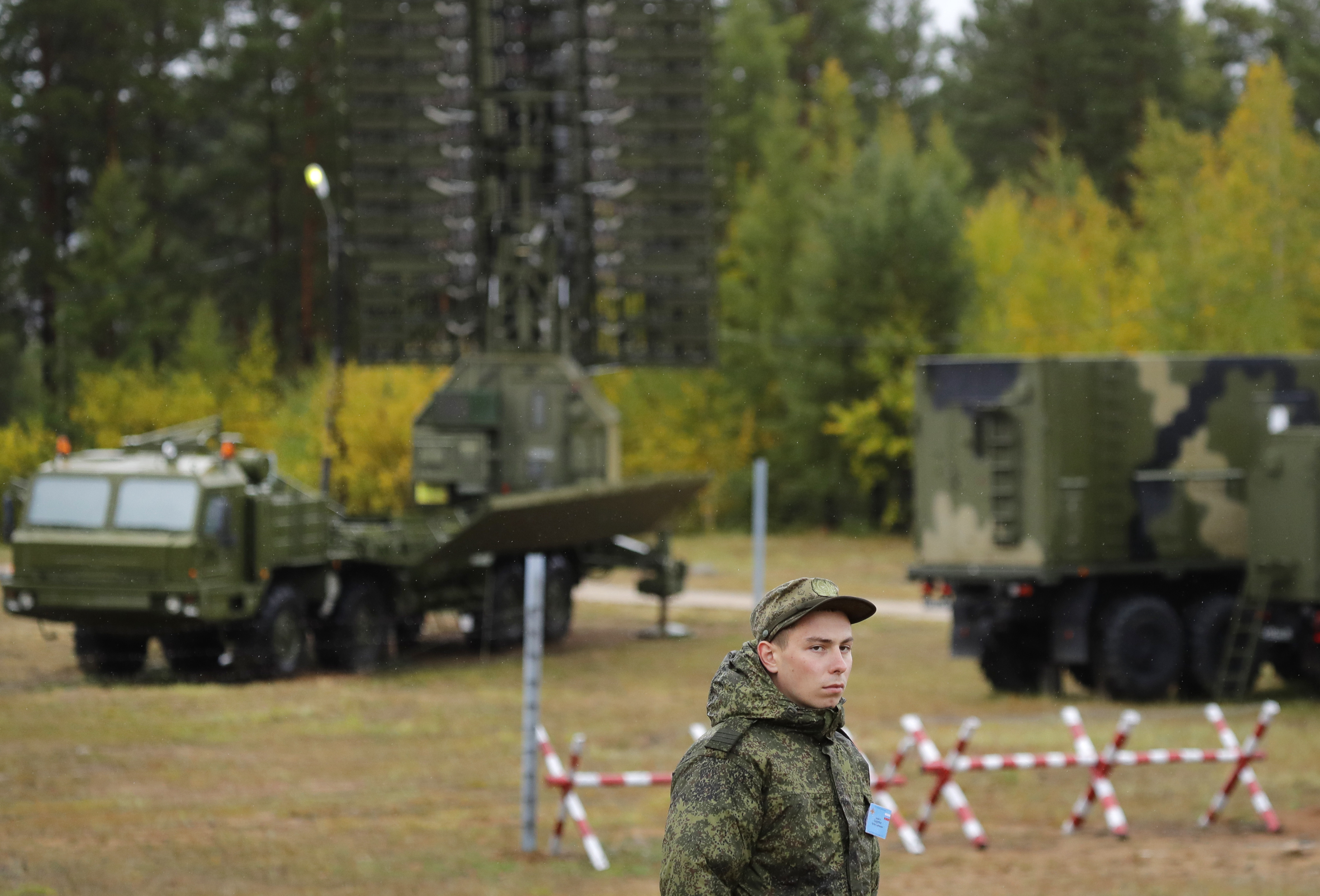 A Russian soldier stands in front of a Nebo-M radar deployed in a forest, during a military exercises on training ground 