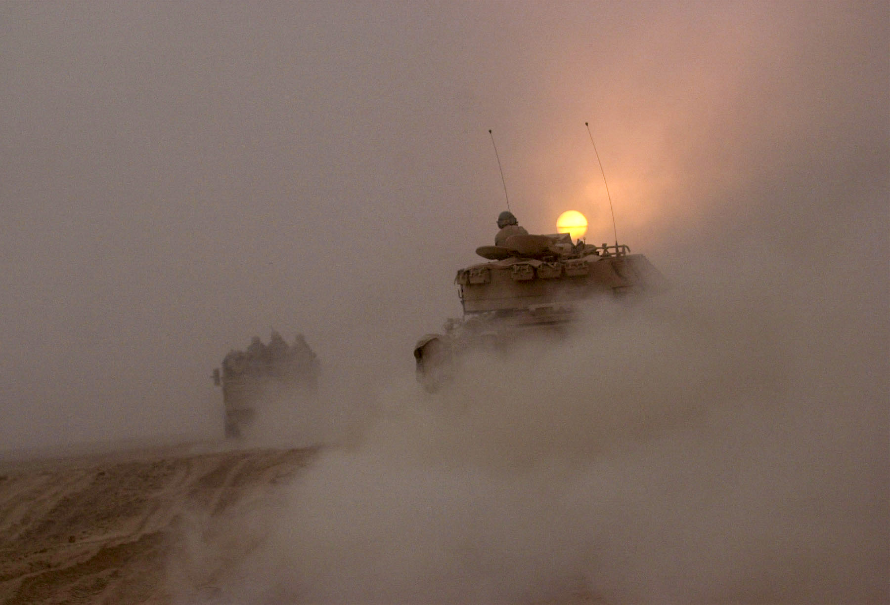 Vehicles from the U.S. Army's 3rd Infantry Division rumble down a road north into Iraq. The Convoy has been moving for two days now on their drive north to take down the Iraqi regime. Up until this point the convoy has received little enemy contact. (Warren Zinn/Army Times)