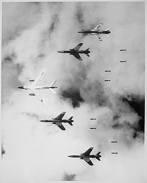 Operation Rolling Thunder, the sustained bombing campaign against North Vietnam, began in 1965. Through 1968, U.S. bombers dropped 643,000 tons of bombs. The weapons killed approximately 52,000 Vietnamese civilians. Here, flying alongside a B-66 Destroyer, Air Force F-105 Thunderchief pilots bomb a military target through low clouds over the southern panhandle of North Vietnam. (National Archives/U.S. Information Agency)
