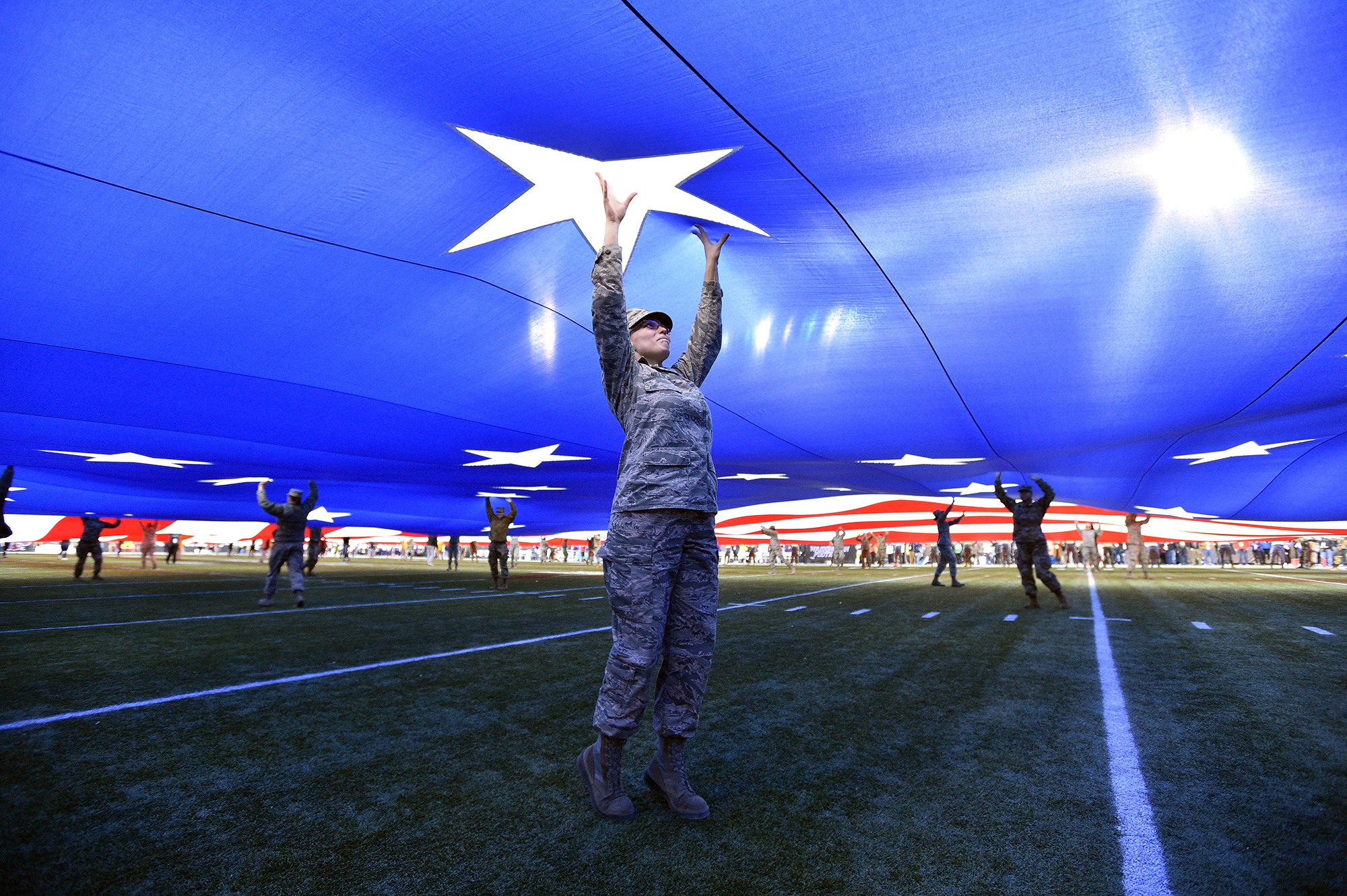 A member of the U.S. Air Force holds up a full-field American flag as it is displayed on the field before the Mitsubishi Motors Las Vegas Bowl between the Washington Huskies and the Boise State Broncos at Sam Boyd Stadium on Dec. 21, 2019 in Las Vegas. (David Becker/Getty Images)