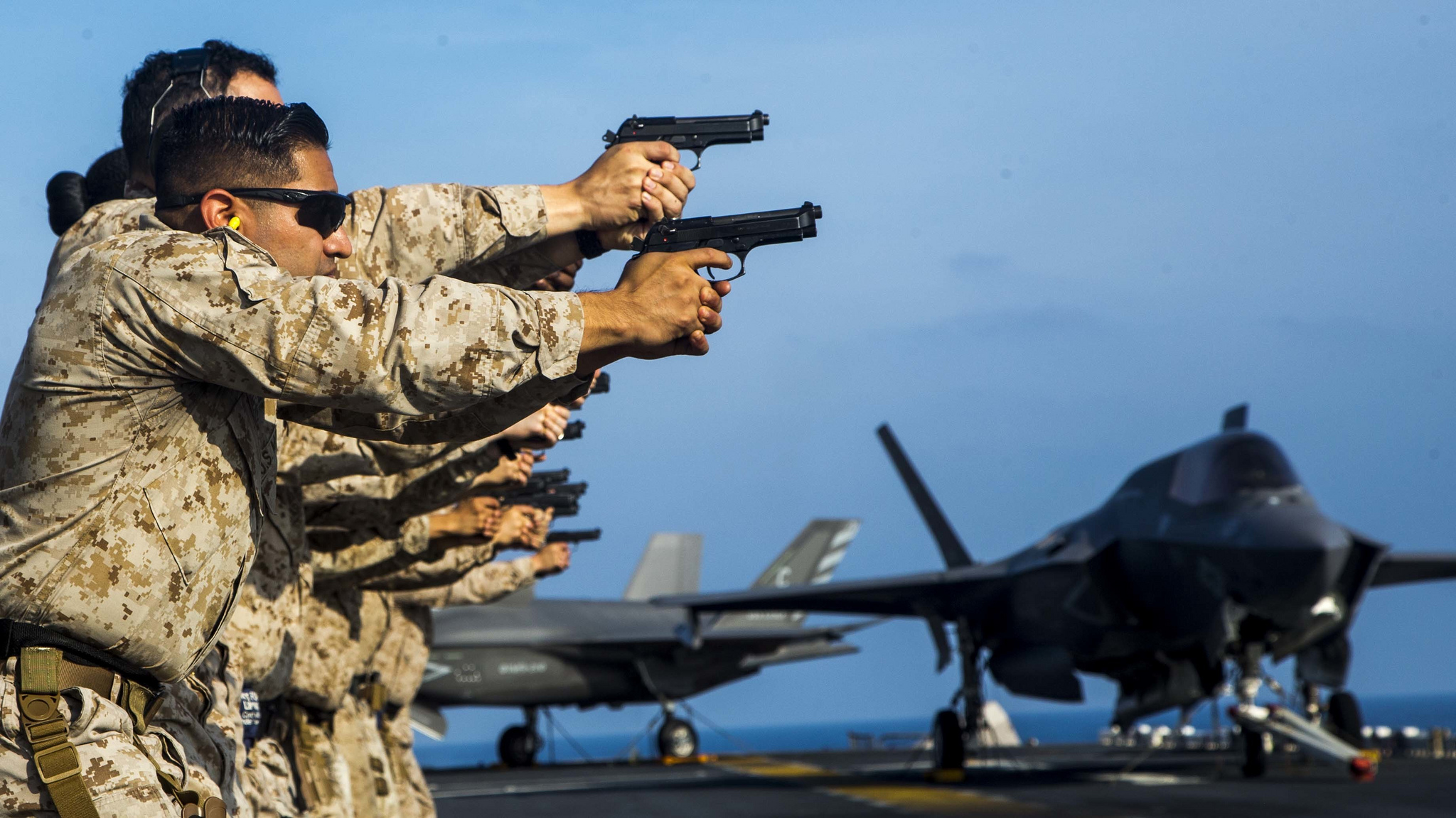 Marines prepare to fire on their targets during a pistol qualification Dec. 17, 2018, aboard the Wasp-class amphibious assault ship USS Essex (LHD 2). (Staff Sgt. Joshua Jackson/Marine Corps)
