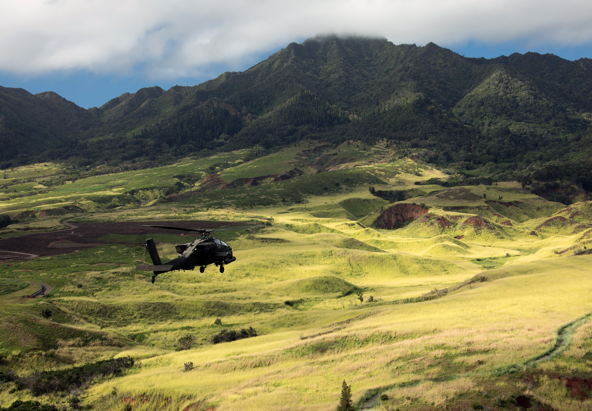 An Army AH-64D Apache helicopter flies in formation for the 25th Infantry Division Review over Schofield Barracks, Hawaii, Dec. 21, 2018. (Staff Sgt. Ian Morales/Army)