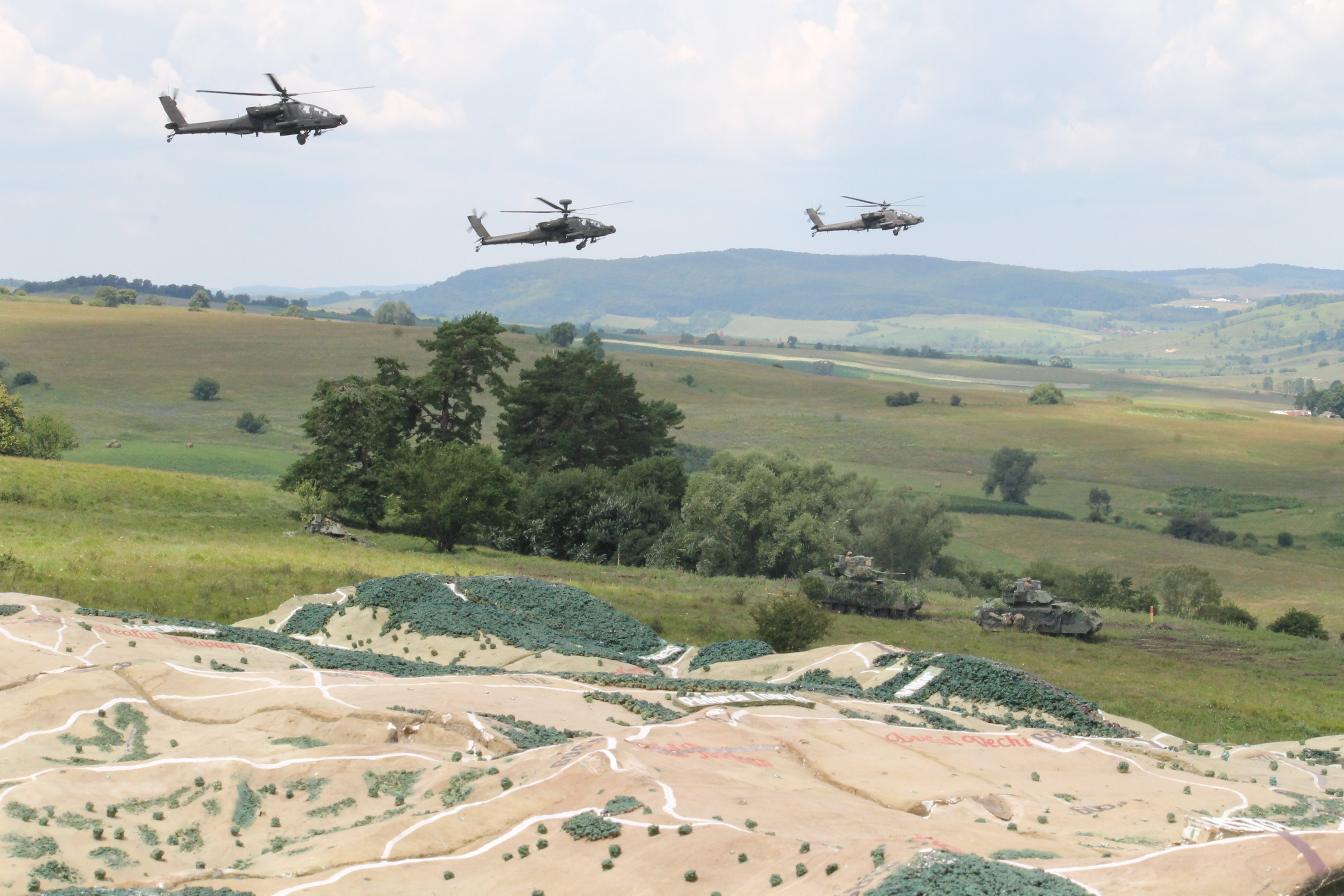 U.S. Apaches fly over the range and a 3-D rendering of the battlefield terrain depicting planned operations. (Jen Judson/Staff)