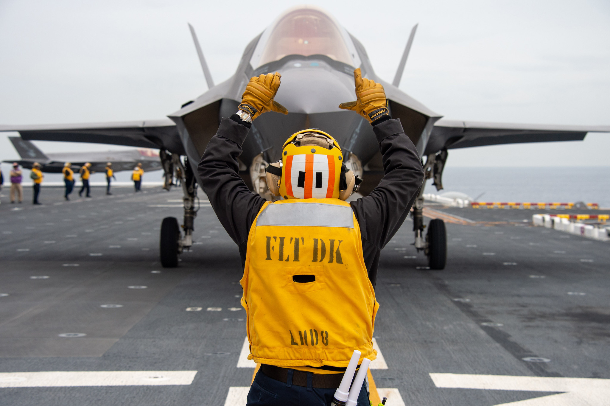 Aviation Boatswains Mate (Handling) 2nd Class Tyler Randrup directs a U.S. Marine Corps F-35B Lightning II aboard the amphibious assault ship USS Makin Island (LHD 8) on Dec. 3, 2019, in the Pacific Ocean. (ass Communication Specialist 3rd Class Jacob D. Bergh/Navy)