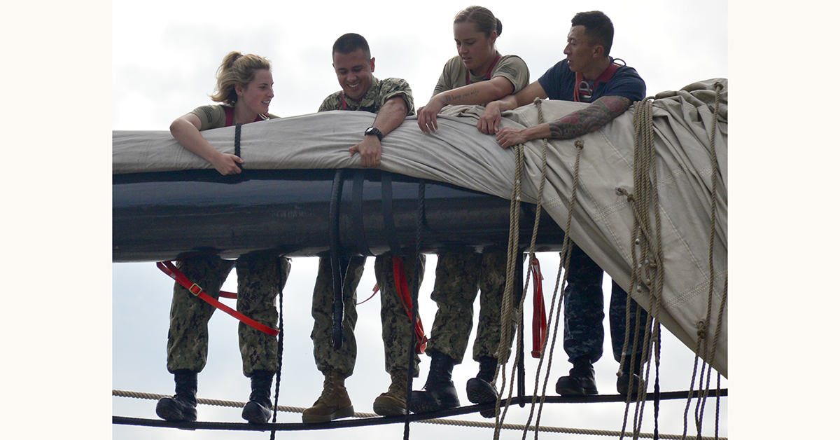 Seaman Emma Hoernline, far left, and Seaman Ashley Watson, middle right, assigned to USS Constitution, assist chief petty officer selectees Construction Mechanic 1st Class Mario PadillaCruz, middle left, and Electrician’s Mate 1st Class Tho Nguyen, far right, while furling USS Constitution’s main topsail during Chief Petty Officer (CPO) Heritage Week. CPO Heritage Week is a week dedicated to mentoring the Navy's newest chiefs through naval history and heritage training aboard America's Ship of State, USS Constitution. (MC3 Casey Scoular/Navy)