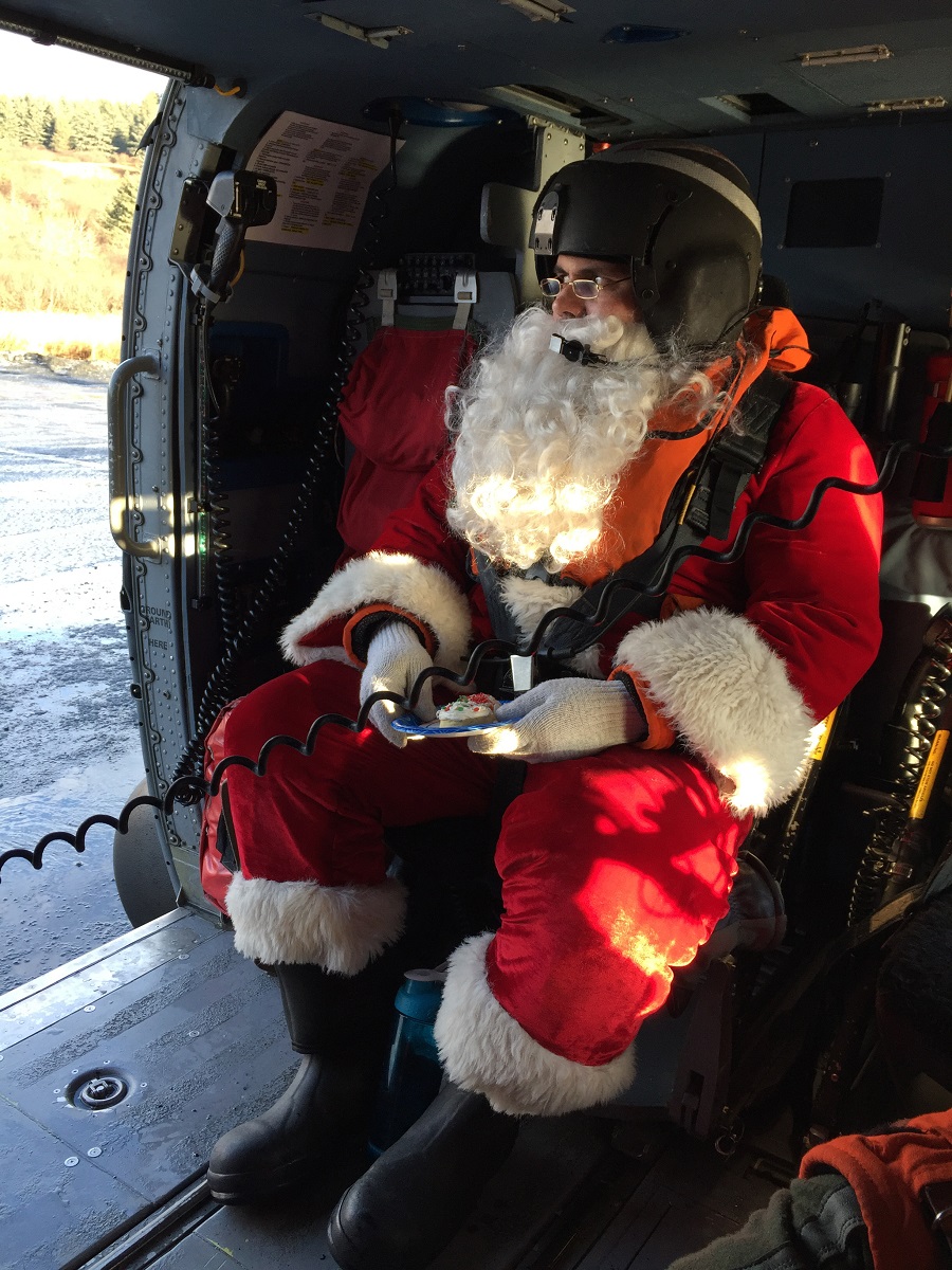 Santa Claus waits in a Coast Guard Air Station Kodiak MH-60 Jayhawk helicopter to take off to take him to the next remote Kodiak Island, Alaska, village, Dec. 5, 2017. (Petty Officer 1st Class Charly Hengen/Coast Guard)