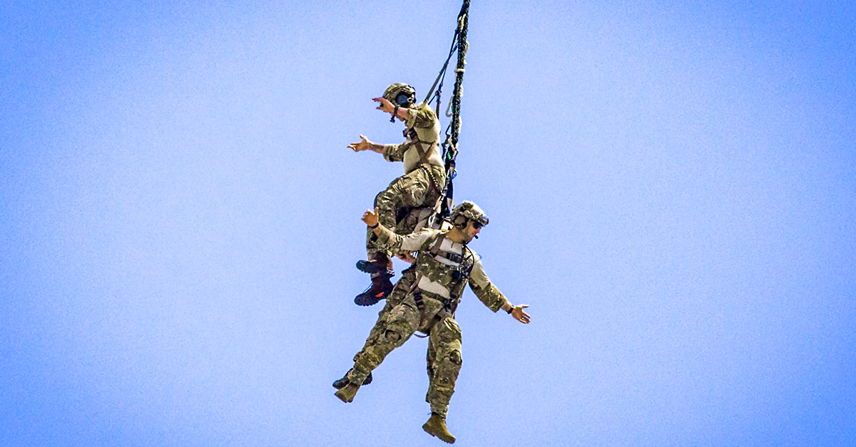 Tactical air control party Airmen with the 227th Air Support Operations Squadron, New Jersey Air National Guard, demonstrate a special extraction system while hanging from a UH-60L Black Hawk helicopter assigned to the 1st Assault Helicopter Battalion, New Jersey Army National Guard, during the 2018 Atlantic City International Airshow at Atlantic City, New Jersey, Aug. 22, 2018. (Mark C. Olsen/New Jersey National Guard)