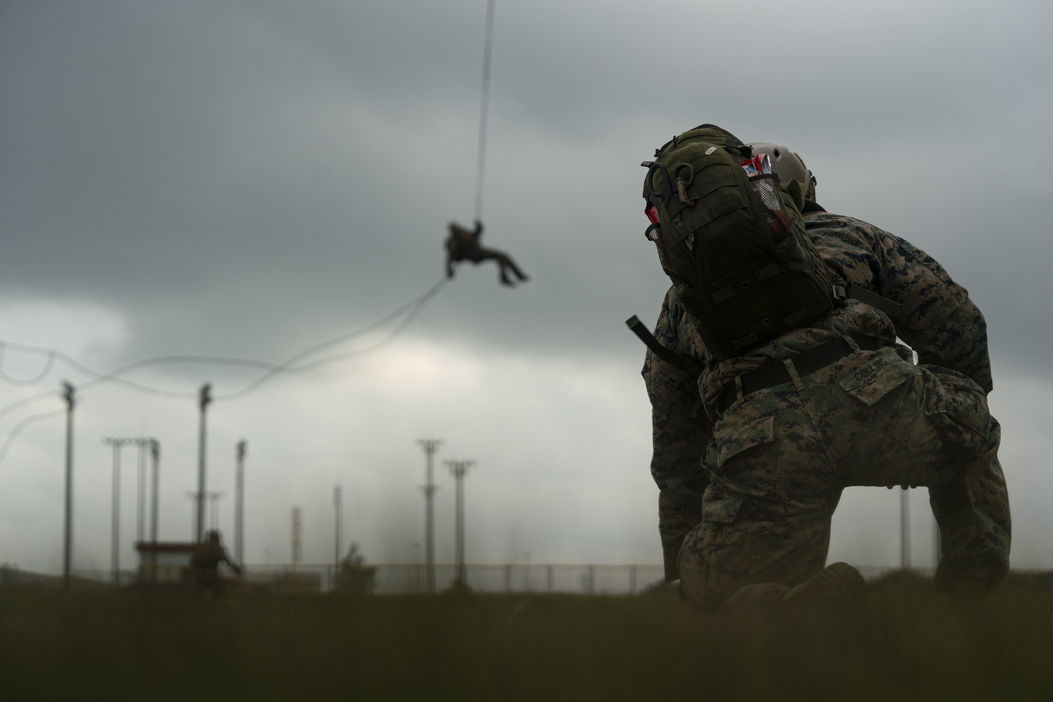 A U.S. Navy corpsman with Expeditionary Operations Training Group, III Marine Expeditionary Force Information Group, supervises students performing helicopter rope suspension technique training at the parade deck on Camp Hansen, Okinawa, Japan, Aug. 14, 2019. (Lance Cpl. Andrew R. Bray/Marine Corps)