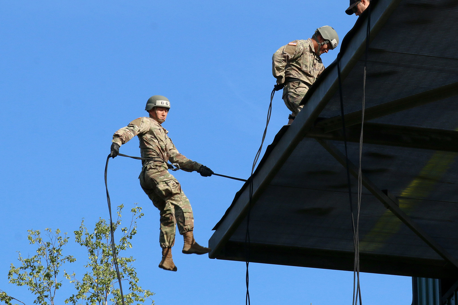 A soldier attending Air Assault School jumps from a 58-foot tower for the first time as he rappels down a rope at Joint Base Elmendorf-Richardson, July 16, 2018. (Sgt. Alex Skripnichuk/Army)