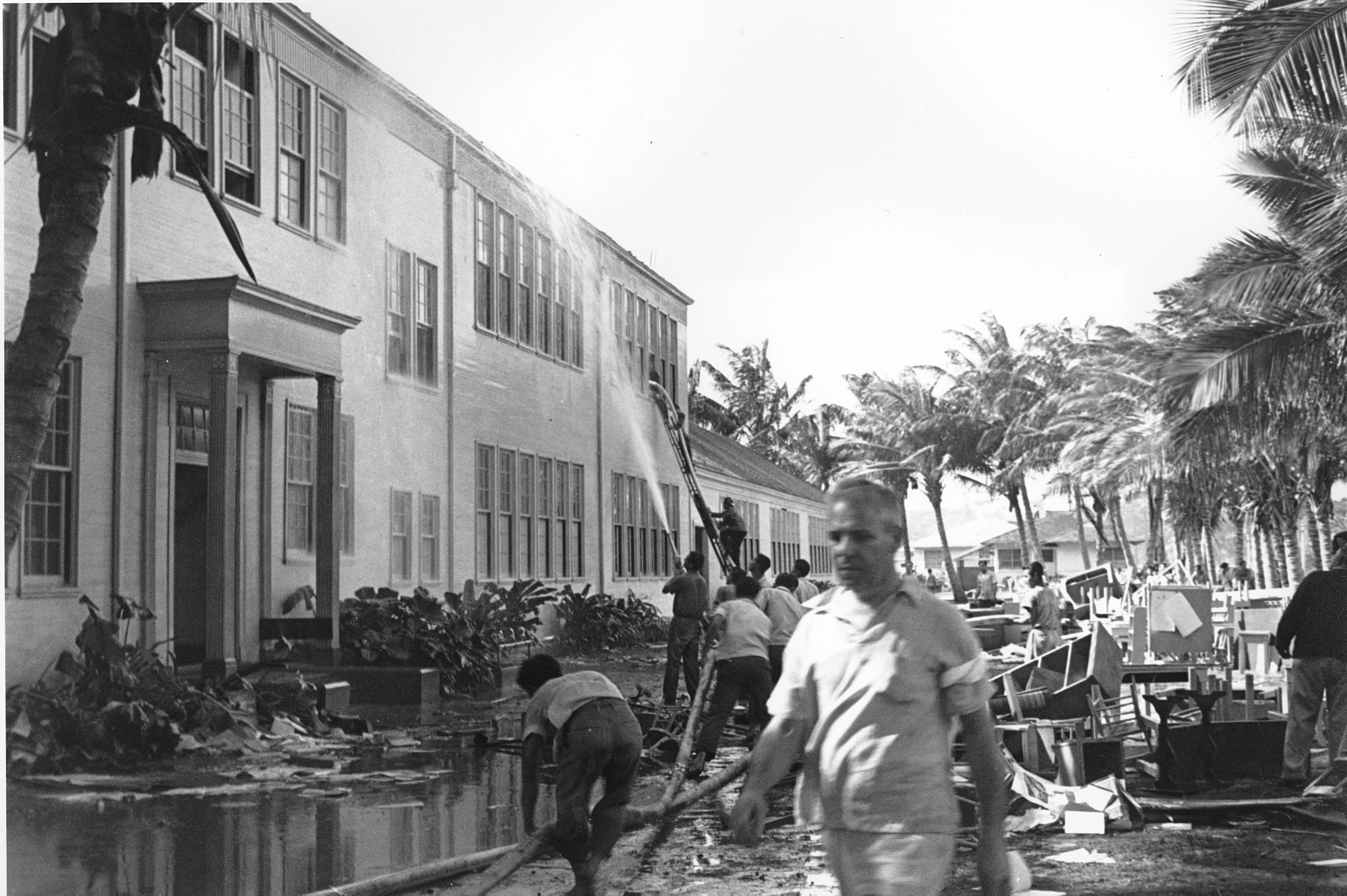 Rescue workers help evacuate the Lunalilo High School in Honolulu after the roof of the main building was hit by a bomb during the Japanese attack at Pearl Harbor, Hawaii on Dec. 7, 1941. (AP Photo)