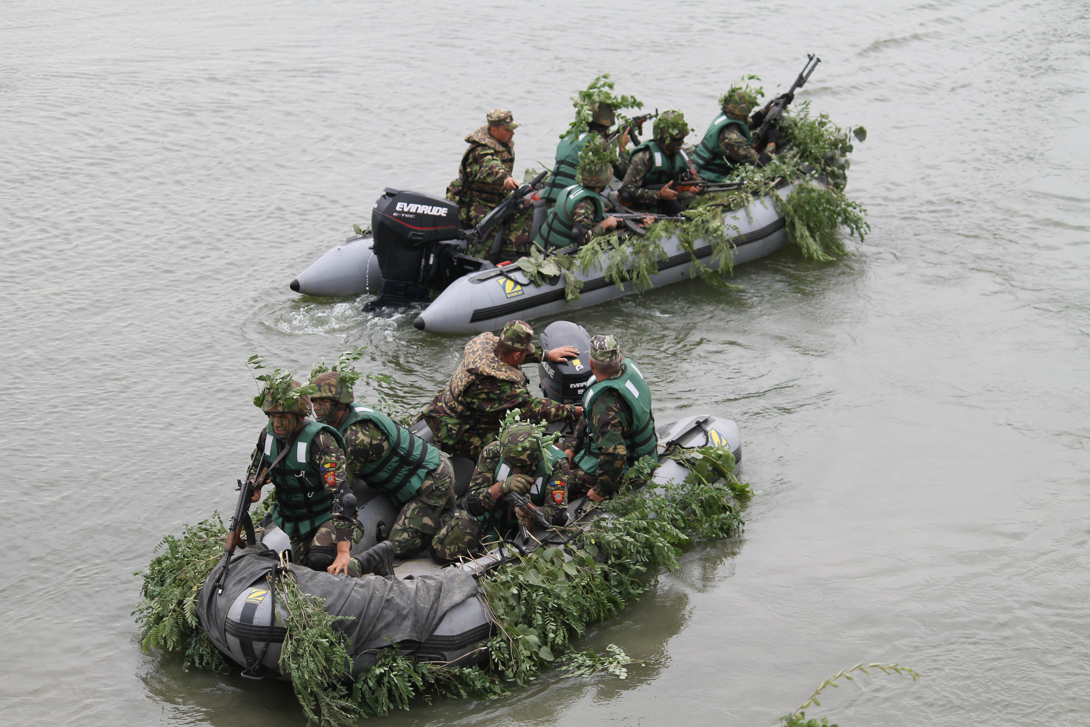 Well-camouflaged Romanian troops load into high-speed rafts within seconds on the side of the Danube and begin the short journey across to support friendly forces on the other shoreline, fending off enemy advances. (Jen Judson/Staff)
