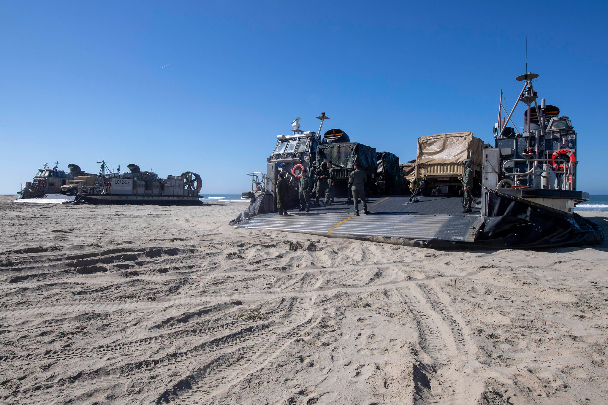 Landing craft air cushions prepare to unload vehicles and Marines on March 30, 2019, in the Indo-Pacific area of operations. (Mass Communication Specialist 2nd Class Kyle Carlstrom/Navy)