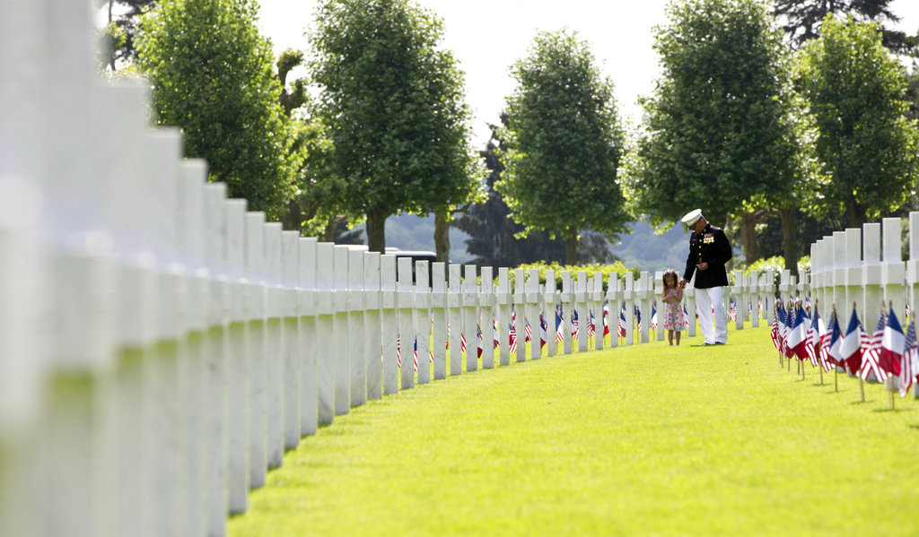 A U.S. Marine walks with a small girl through headstones prior to a Memorial Day commemoration at the Aisne-Marne American Cemetery in Belleau, France, Sunday, May 27, 2018. The cemetery contains more that 2,000 American dead. (Virginia Mayo/AP)