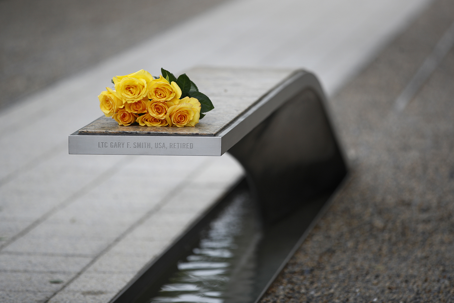 Flowers rest on a bench bearing a name in memory of retired U.S. Army Lt. Col. Gary Smith before a ceremony in observance of the 18th anniversary of the Sept. 11 attacks at the Pentagon in Washington, Wednesday, Sept. 11, 2019. (Patrick Semansky/AP)