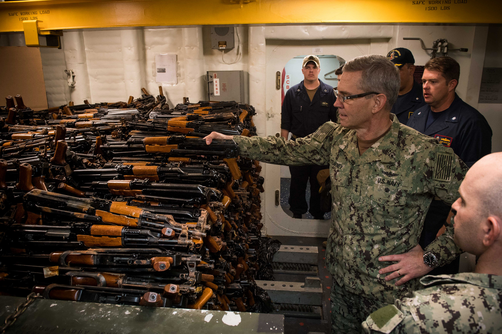 Vice Adm. Scott Stearney, commander of U.S. Naval Forces Central Command, U.S. 5th Fleet and Combined Maritime Forces, looks at a cache of over 2,500 AK-47 automatic rifles seized during maritime security operations aboard the guided-missile destroyer USS Jason Dunham (DDG 109) on Oct. 24, 2018, in Manama, Bahrain. (MC3Jonathan Clay/Navy)