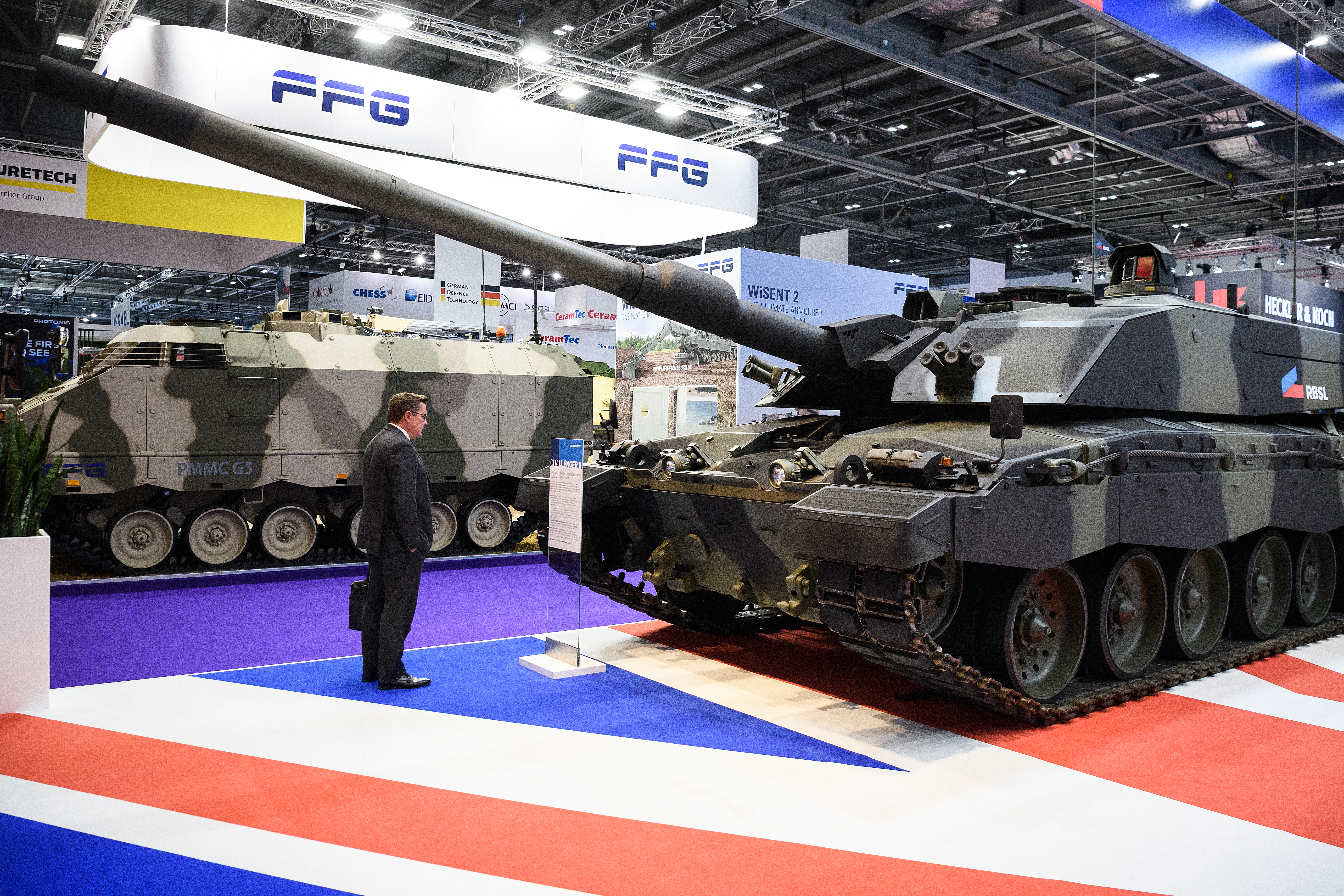 A delegate studies a Challenger II tank at DSEI. In London's Doclands area, the biennial event is the world's largest arms fair. (Leon Neal/Getty Images)
