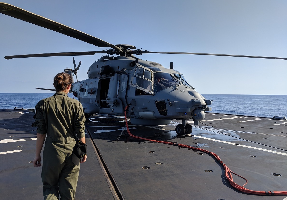 A member of the aircrew walks across the flight deck to prepare for an afternoon flight in the Alpino's NH90 helicopter. (David B. Larter/Staff)