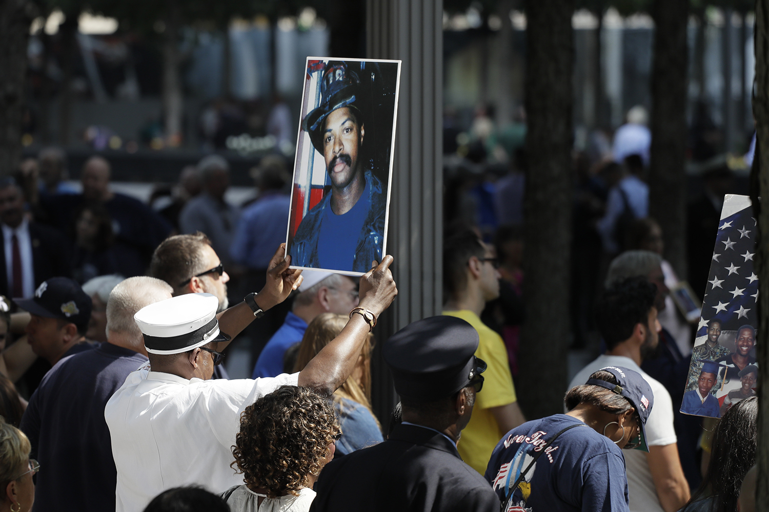 A photograph of fallen firefighter Leon Smith, Jr. is held up during a ceremony marking the 18th anniversary of the attacks of Sept. 11, 2001 at the National September 11 Memorial, Wednesday, Sept. 11, 2019 in New York. (Mark Lennihan/AP)