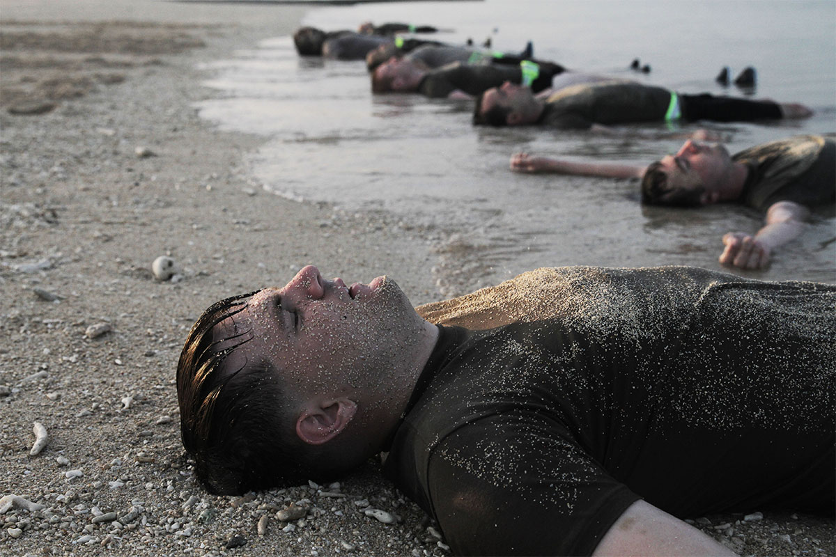 Soldiers from of the Special Forces Basic Combat Course wash off on the beach shore after a morning physical fitness training session at Torii Station, Okinawa, Japan. (Spc. Aaron Agee/Army)