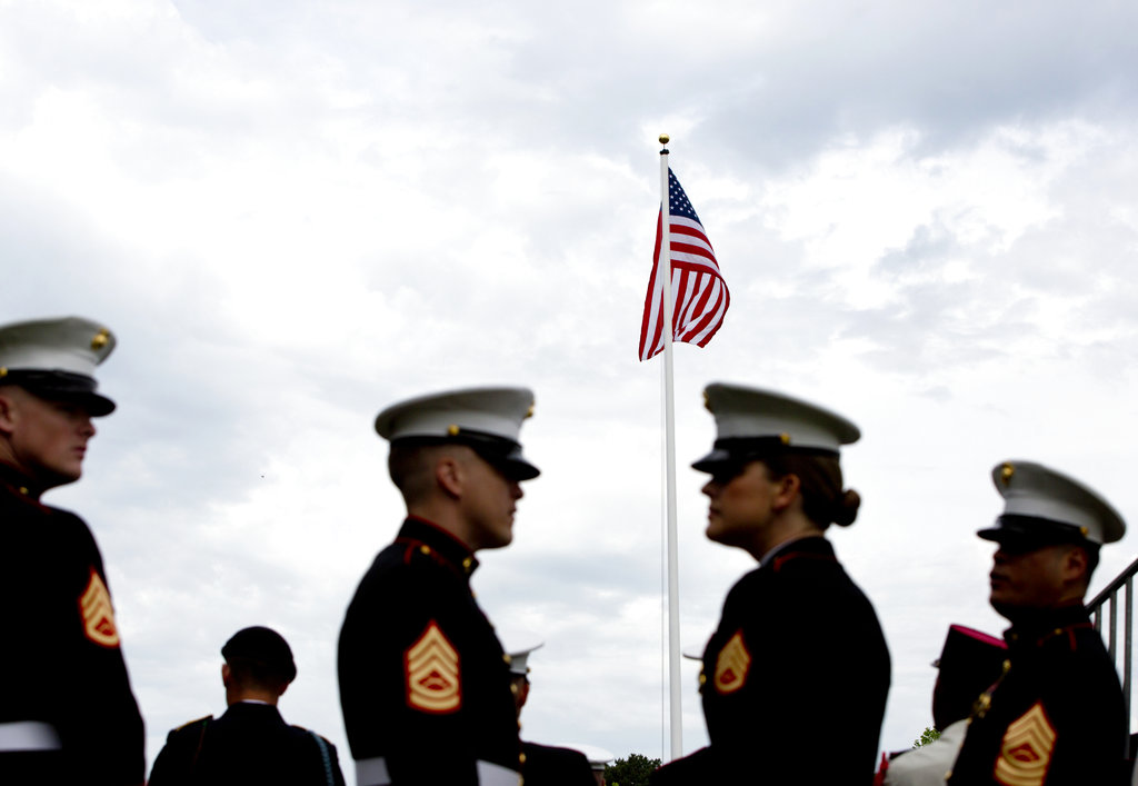 U.S. Marines stand beneath the American flag during a Memorial Day commemoration at the Aisne-Marne American Cemetery in Belleau, France, Sunday, May 27, 2018. (Virginia Mayo/AP)
