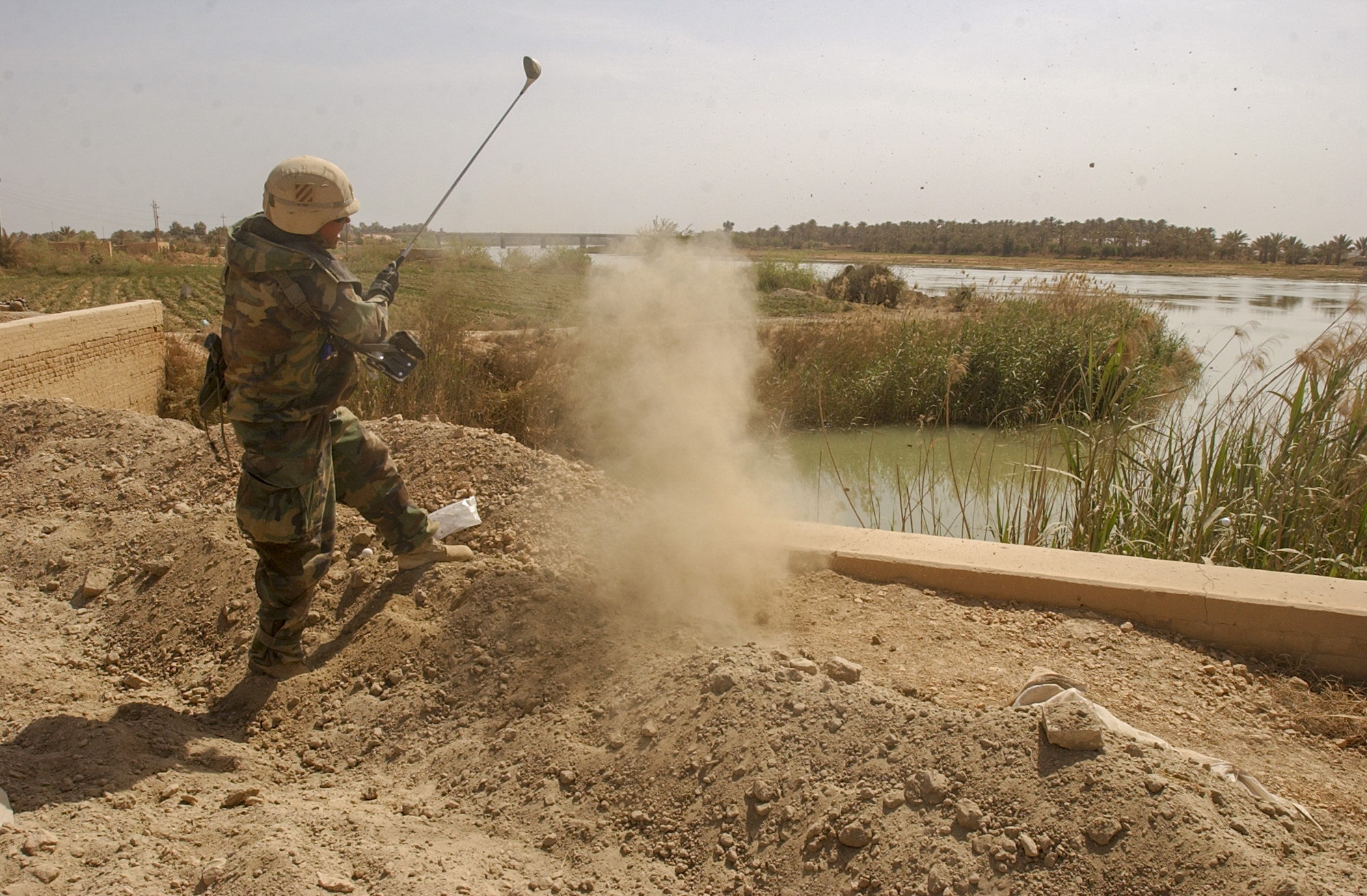 Major Brad Gavle, 39 from Decorah, Iowa of the 3rd Squadron, 7th Cavalry Regiment takes a moment during a pause in combat to hit a golf ball into the Euphrates River on April 3, 2003, 20km south of Baghdad, Iraq. A major assault was launched last night by the 3rd Infantry Division as the division makes it way towards Baghdad. (Warren Zinn/Army Times)