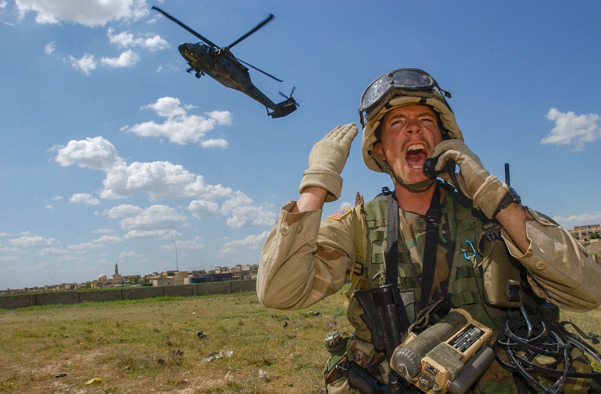 Sgt. Daniel Wiser, 25, of Waukesha, WI,yells to his section to haul ass back to the landing zone as he talks to the Blackhawk pilots before reboarding the plane as soldiers inspect vehicles in Mosul Wednesday, 4/30/03. The headquarters mortars, 3rd Battalion, 502nd Infantry Regiment, 101st Airborne Division (Air Assault) section is using the UH-60 Blackhawk helicopter to conduct searches to locate and shut down black market activity in the third largest city in Iraq. (Rob Curtis/Army Times)