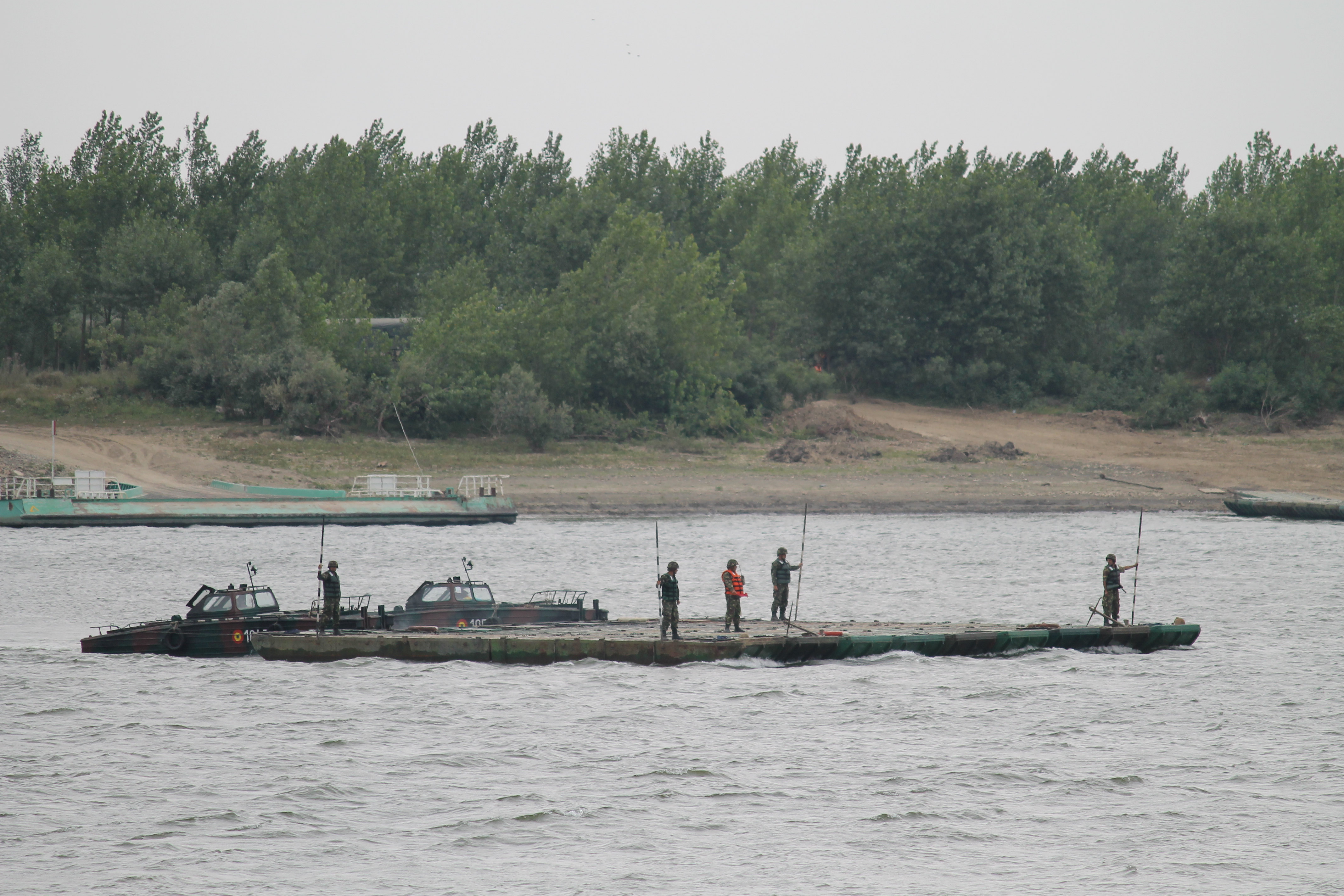 Once the banks are secured, the final piece of the bridge is guided out to where it will complete the chain. The bridging capability is resident in the Romanian military. The U.S. and allies in the region continue to exercise bridging capabilities, something of which the U.S. has very little. All of U.S. bridging capability resides within the reserve forces but is being seen as increasingly important as the U.S. and its allies in Europe strengthen skills needed to operate in the region. (Jen Judson/Staff)