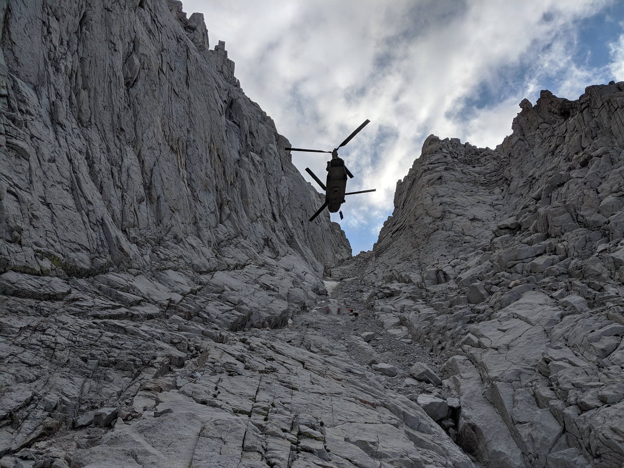A California Army National Guard CH-47F Chinook helicopter hovers Aug. 25, 2019, as an injured hiker is hoisted on a litter from an area 13,800 feet up Mount Whitney in Inyo County, Calif. (Photo courtesy Inyo County Search and Rescue)