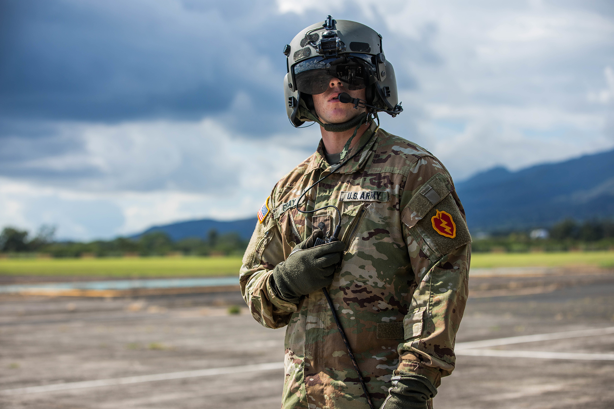 Spc. Jon Gray, a crew chief with 25th Combat Aviation Brigade, gets ready for the official review of the 25th Infantry Division’s soldiers, complete with flyover from 25th CAB helicopters Oct. 31, 2019, at Schofield Barracks, Hawaii. Soldiers wear the 25th Infantry Divisions colored patch during Tropic Lightning Week which is the first time it is displayed with the OCP uniform. (Sgt. Sarah D. Sangster/Army)