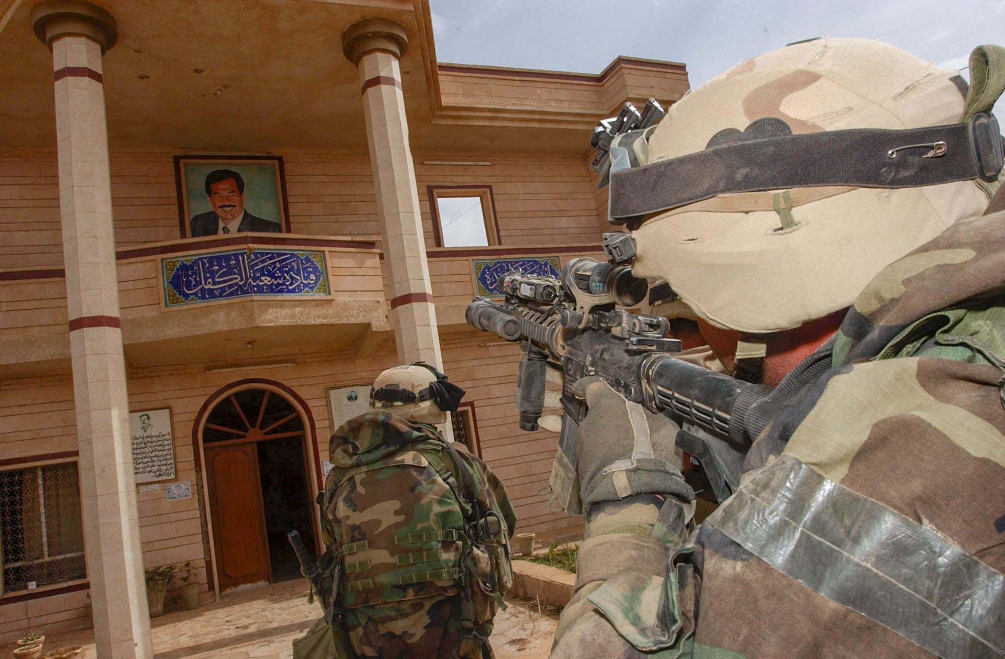 Members of Delta Company, 3rd Battalion, 502nd Infantry Regiment, 101st Airborne Division (Air Assault) go room to room, clearing the local Baath Party Headquarters in Al Kifl Sunday, 3/30/03 (3pm). The soldiers found documents, weapons, and full grain bags hidden inside the walled compound. (Rob Curtis/Army Times)