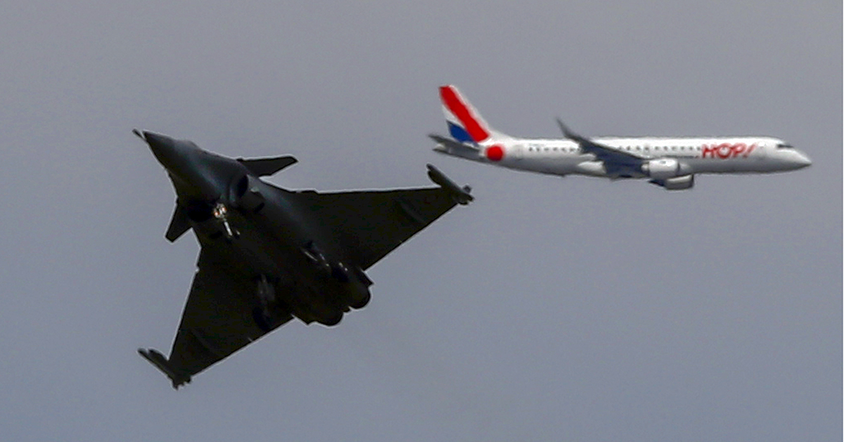 A Dassault Rafale fighter jet performs a demonstration flight as a passenger aircraft flies in the background at the Paris Air Show in Le Bourget, northeast of Paris, France, on June 18, 2019. (Francois Mori/AP)