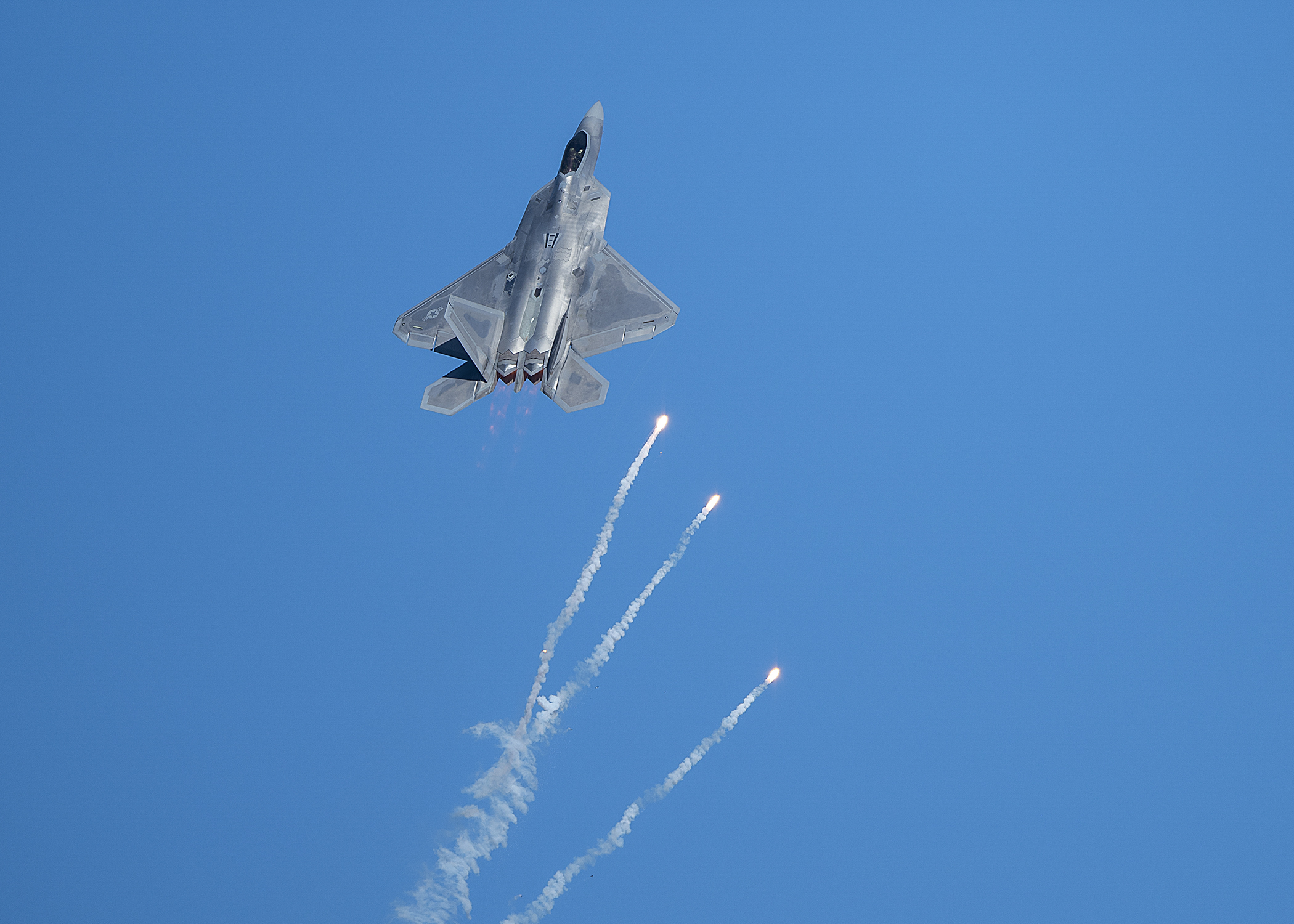 A 433rd Weapons Squadron F-22 Raptor fighter jet pops flares during the Aviation Nation 2019 air show at Nellis Air Force Base, Nev., Nov. 16, 2019. (Airman 1st Class Bryan Guthrie/Air Force)