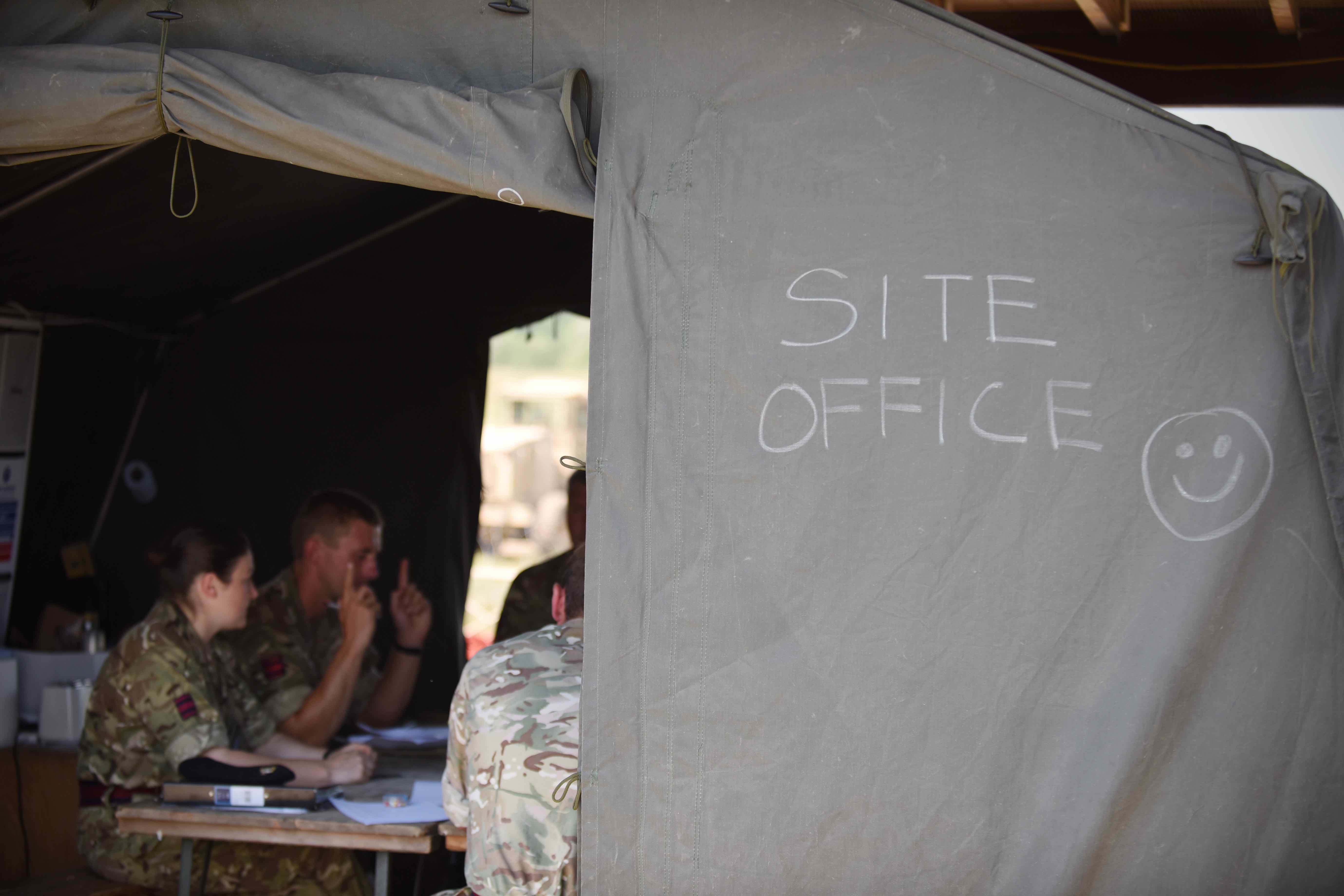 Engineers discuss construction plans inside a tent. While the soldiers encountered interoperability issues from language barriers to using the metric system, they quickly adapted to varying procedures and learned to communicate, even through a form of sign language. (Jen Judson/Staff)