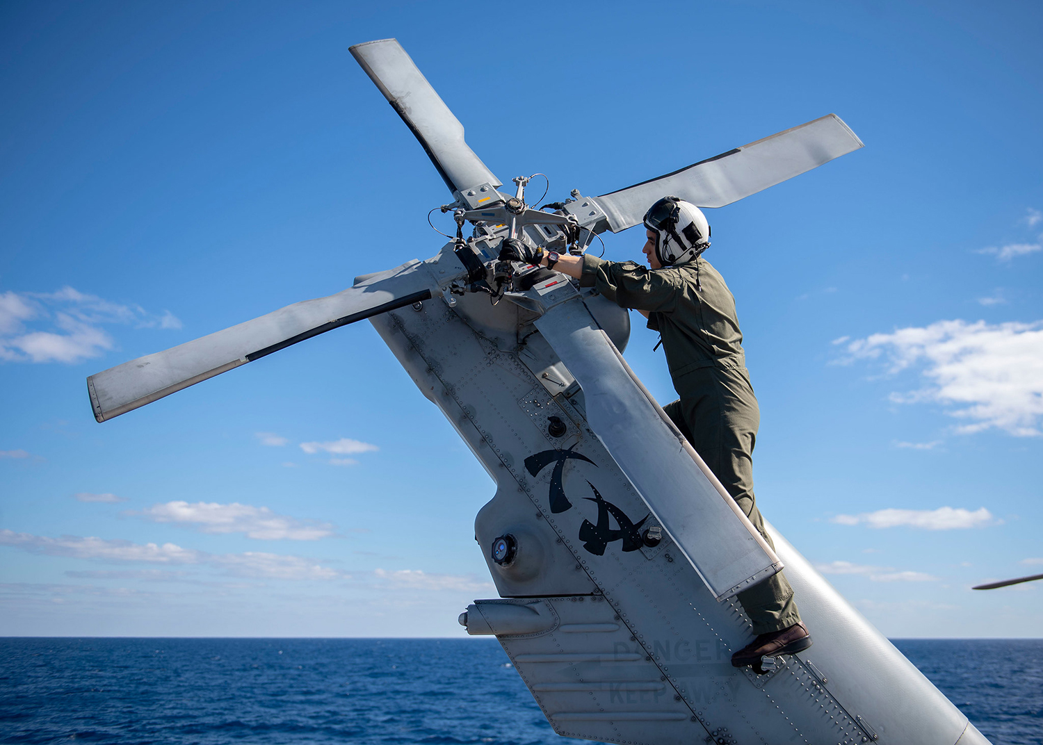 Lt. Austin Gallegos verifies tail rotor integrity on a MH-60R Sea Hawk on July 19, 2019, aboard the Ticonderoga-class guided-missile cruiser USS Chancellorsville (CG 62) in the Coral Sea. (Mass Communication Specialist 2nd Class John Harris/Navy)