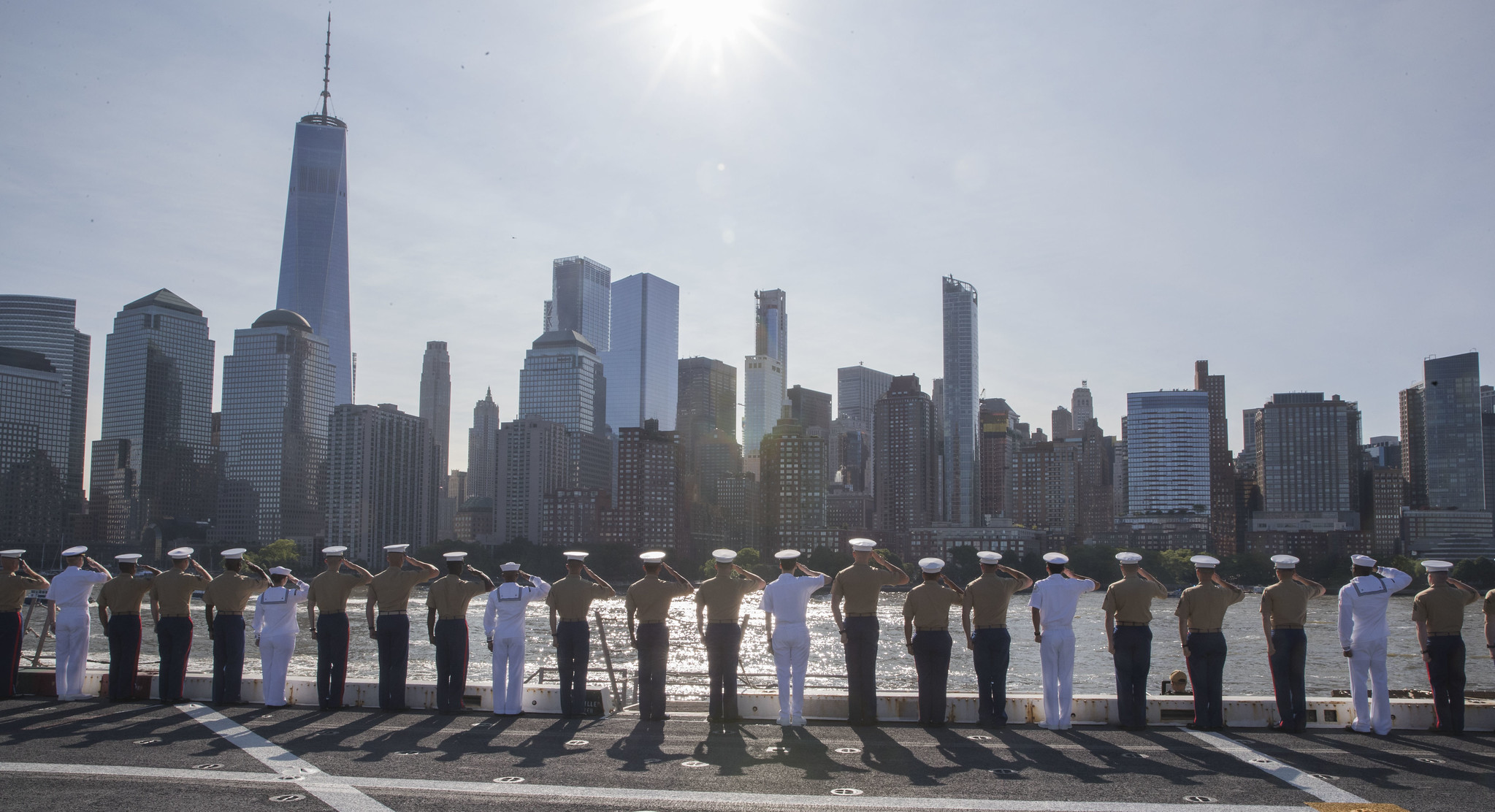 Sailors and Marines salute the Freedom Tower from the flight deck of the amphibious transport dock ship USS New York (LPD 21) on May 22, 2019, while transiting the Hudson River as they head to a pier in Manhattan during Fleet Week New York. (Mass Communication Specialist 2nd Class Ryan Seelbach/Navy)