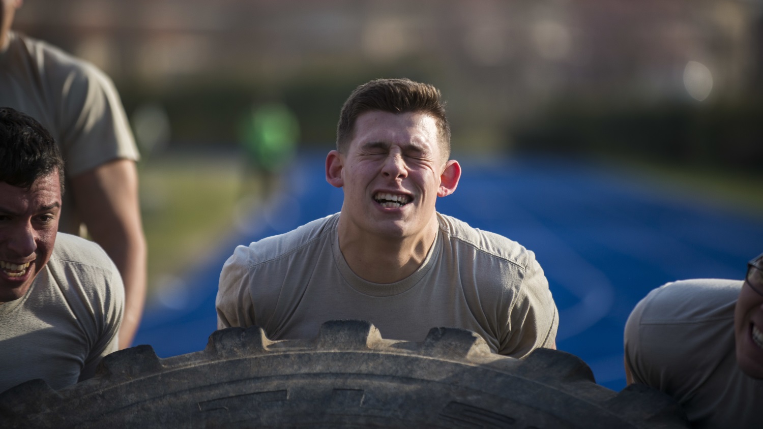 Airman 1st Class Nicholas Castellucci, 724th Air Mobility Squadron member, flips a tire with his teammates during the first Combat Warrior Challenge at Aviano Air Base, March 14, 2017. The four-day competition included obstacles such as a wall climb, tire flip, and kettle bell carry. (Senior Airman Cory W. Bush/Air Force)