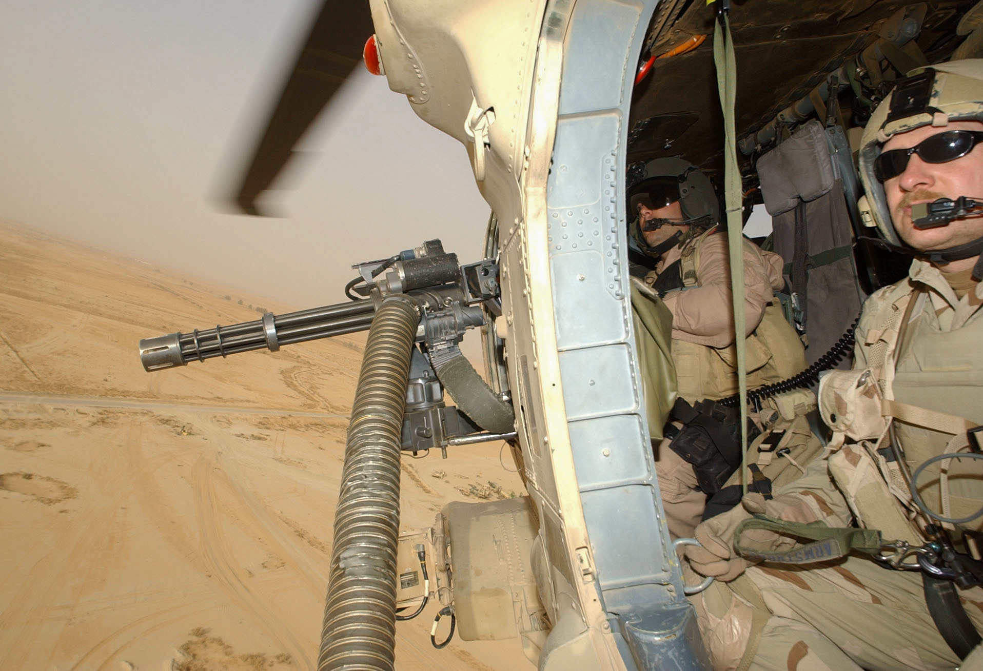 Staff Sgt.. Anthony Pieske, left, door gunner on HH-60 Pavehawk, mans gun next to pararescueman Master Sgt. David Armstrong, right, while flying a search and rescue flight over southern Iraq on Monday. (Alan Lessig/Air Force Times)