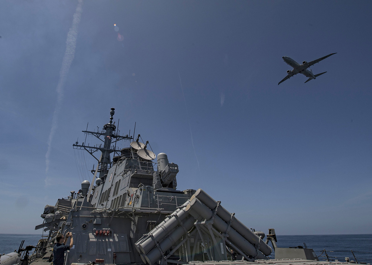 A P-8 Poseidon flies over the Arleigh Burke-class guided-missile destroyer USS Carney (DDG 64) during a air defense exercise, June 19, 2019, in the Atlantic Ocean. (Mass Communication Specialist 1st Class Fred Gray IV/Navy)