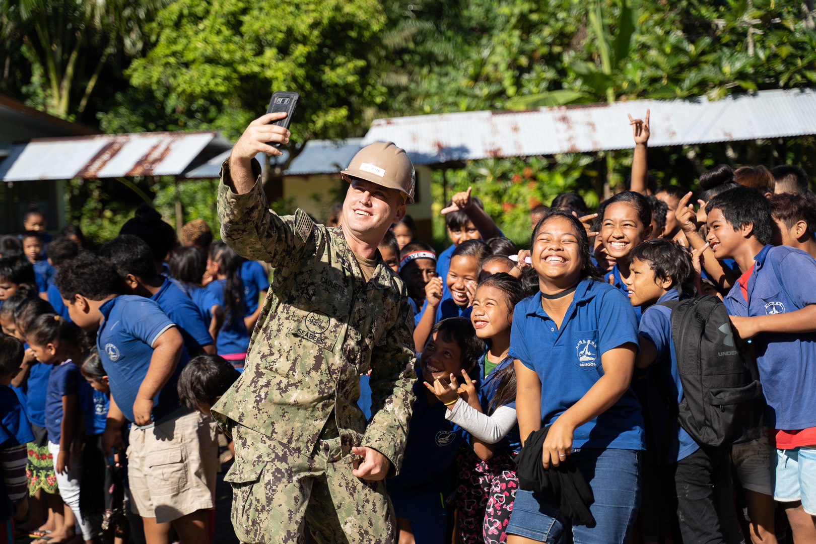 Equipment Operator Constructionman James Caouette takes a selfie with students from Pehleng Elementary School during the opening ceremony for the school’s renovations on Nov. 7, 2019, in Pohnpei, Micronesia. (Builder 3rd Class Christian Carlson/Navy)