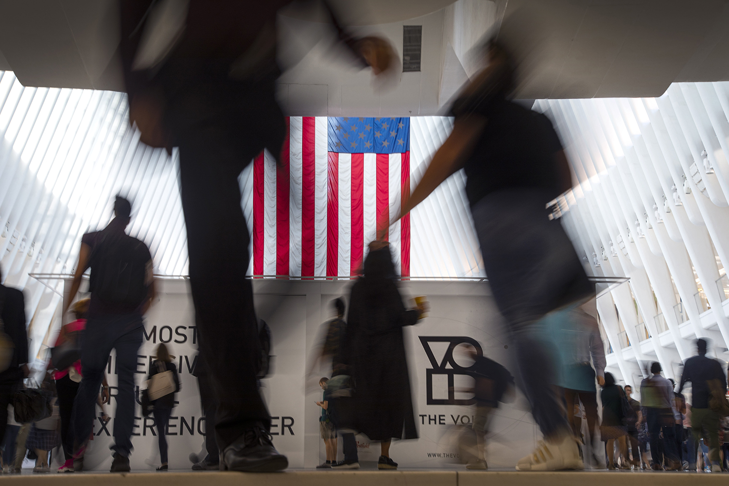 People walk past an American flag at the start of a work day, at the Oculus, part of the World Trade Center transportation hub in New York, Wednesday, Sept. 11, 2019, on the 18th anniversary of 9/11 terrorist attacks. (Wong Maye-E/AP)