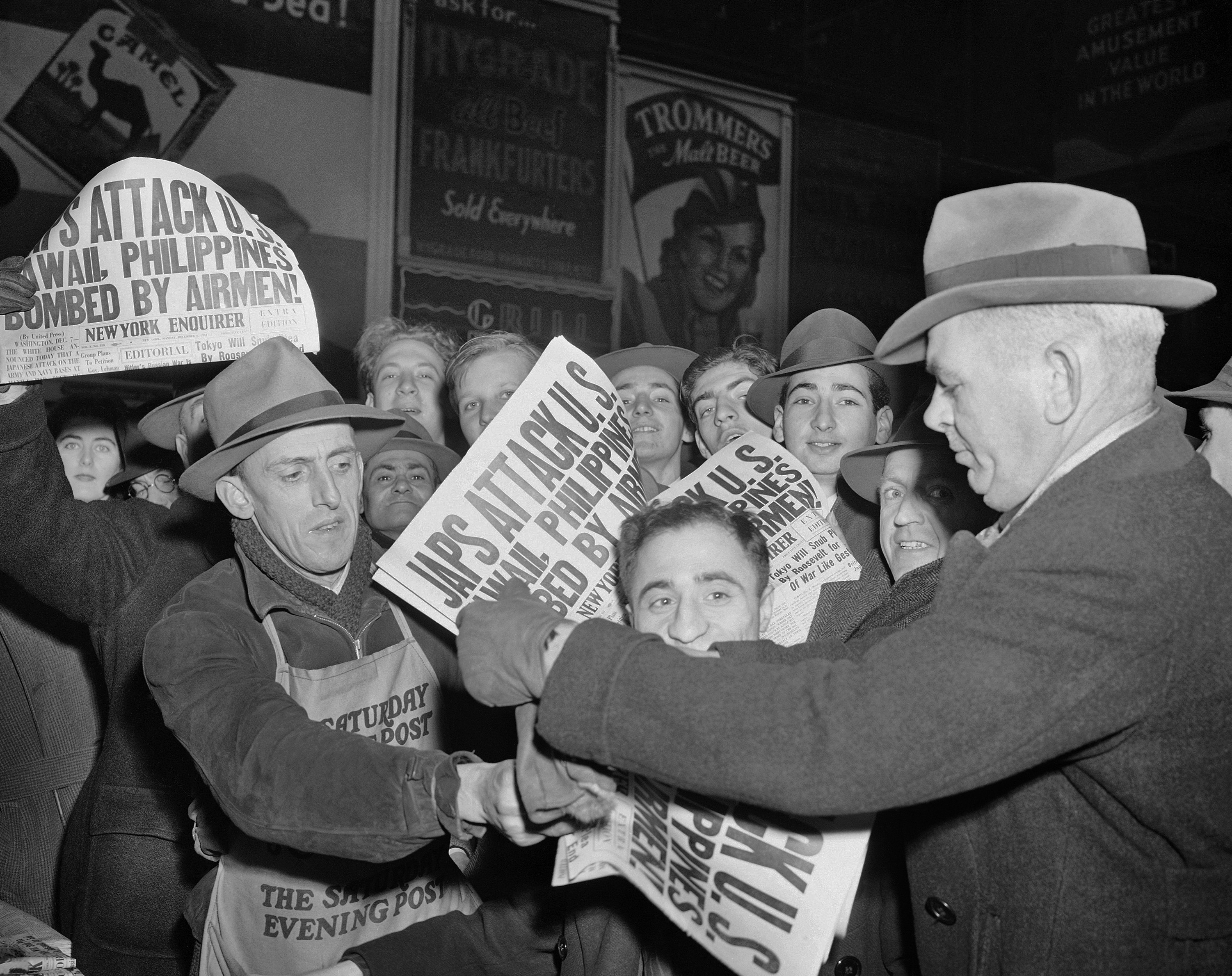 FILE - In this Dec. 7, 1941 file photo, people buy newspapers reporting the Japanese attack on U.S. bases in the Pacific Ocean, at Times Square in New York. (AP Photo/Robert Kradin)