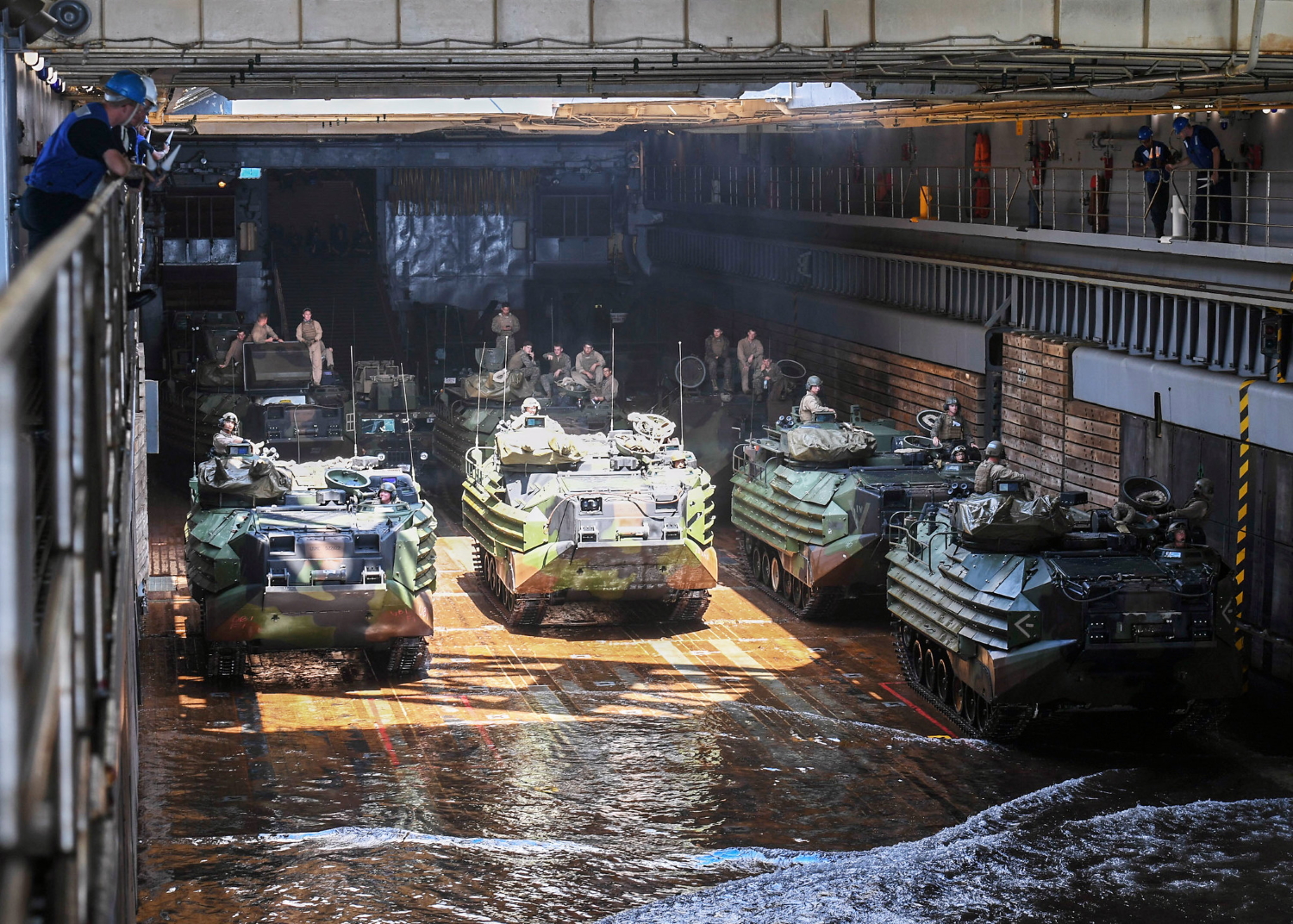 Sailors and Marines guide amphibious assault vehicles into the well deck aboard the Whidbey Island-class dock landing ship USS Germantown (LSD 42) on Oct. 4, 2019, in the Philippine Sea. (Mass Communication Specialist 1st Class Toni Burton/Navy)