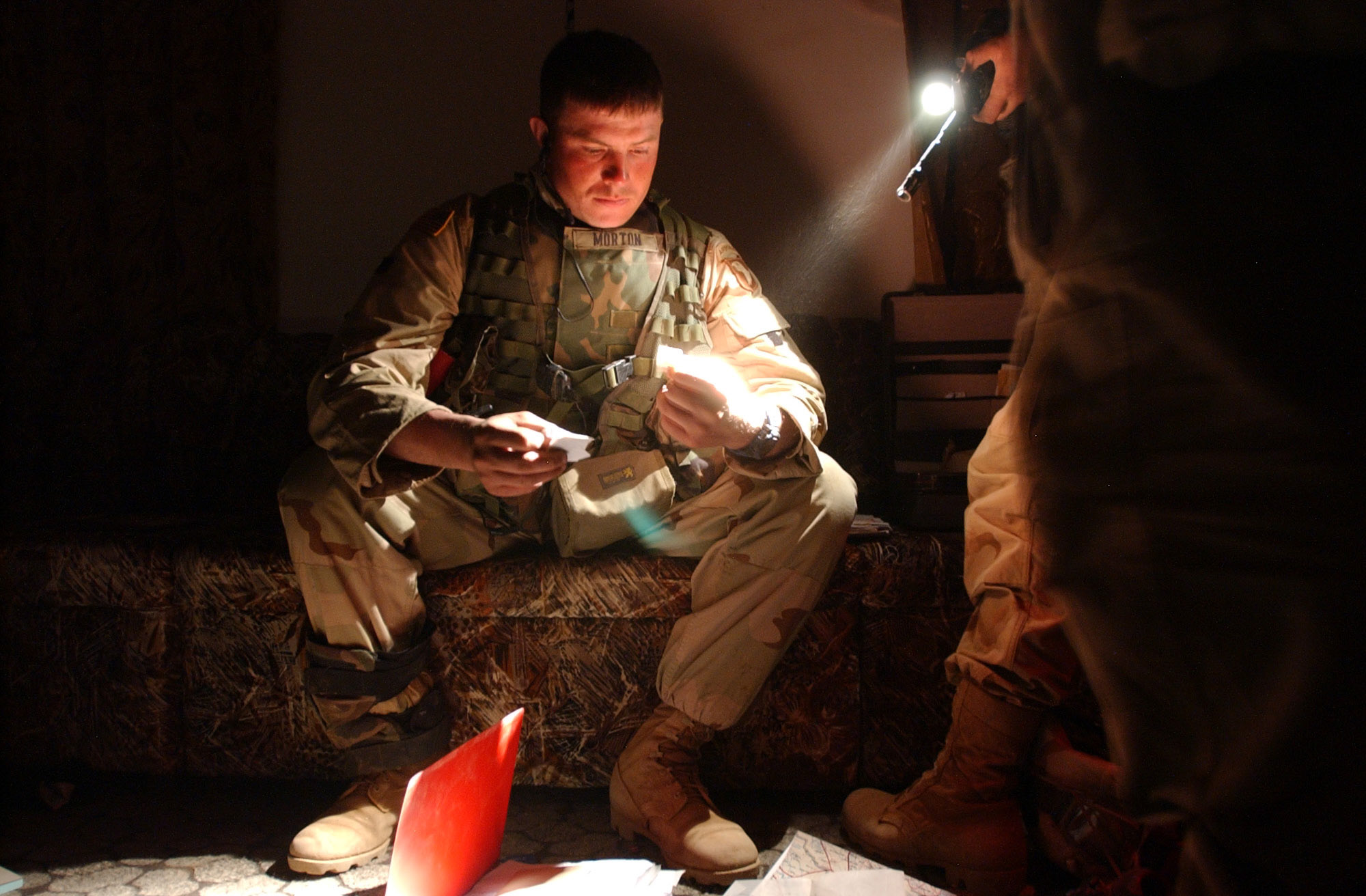 Staff Sgt. Todd Morton, 27, from Cohoes, NY, looks through documents and maps found after 2nd platoon, bravo company, 3rd Battalion, 2nd Brigade, 101st Airborne Divison (Air Assault) occupied a hastily abandoned residence during the Brigade's southern movement toward the city of An Najaf, Wednesday, 4/2/03. The infantry company searched several buildings turning up uniforms, communication equipment and gas masks, vehicles , dozens of small and large caliber weapons, RPGs, US style uniforms and other personal items, as well as uncovering at least two BM21, a Russian made Multiple Launch Rocket System (MLRS). (Rob Curtis/Army Times)