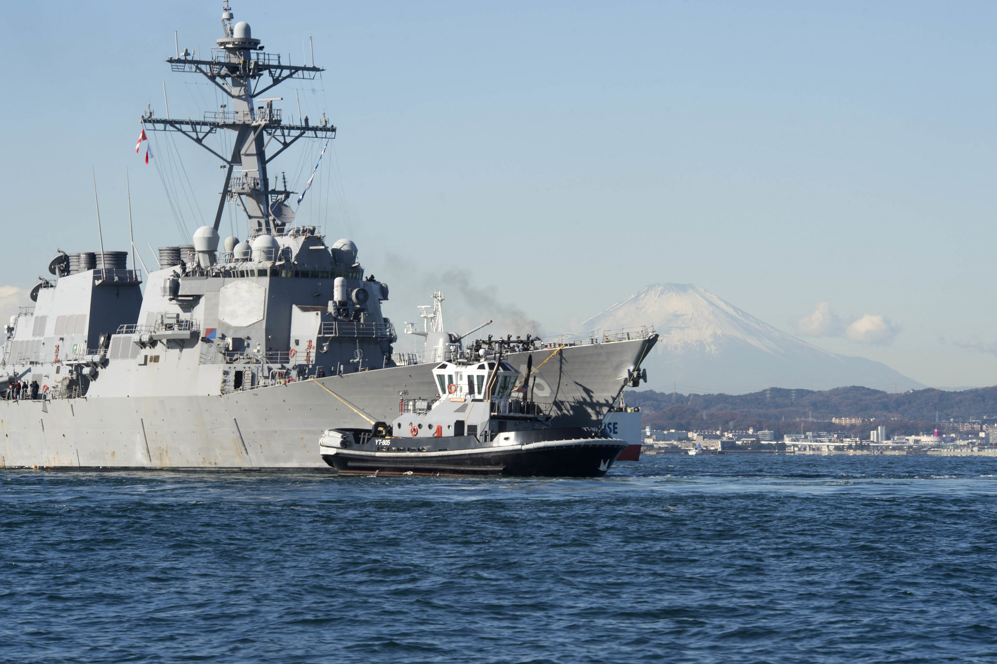 The Arleigh Burke-class guided-missile destroyer USS John S. McCain (DDG 56) is towed to the pier at Fleet Activities Yokosuka on Dec. 13, 2017. John S. McCain will undergo repairs at Ship Repair Facility – Japan Regional Maintenance Center in Yokosuka. (MC2 William McCann/Navy)