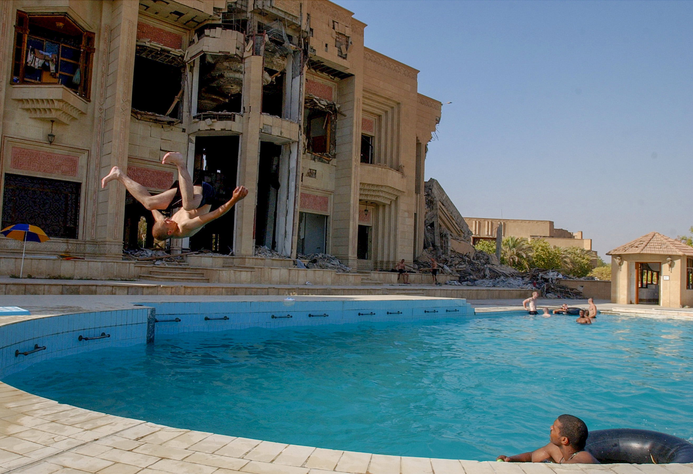 Baghdad, Iraq 07/09/03 Soldiers with 2nd Bat., 3rd Field Art. Regiment, 1st A.D. take some down time to go swimming in the pool at their resdience, Uday Hussein's old palace. While some of the buildings are destroyed the rest are occupied by soldiers, with soldiers living in every available space in the compund. (Warren Zinn/Army Times)