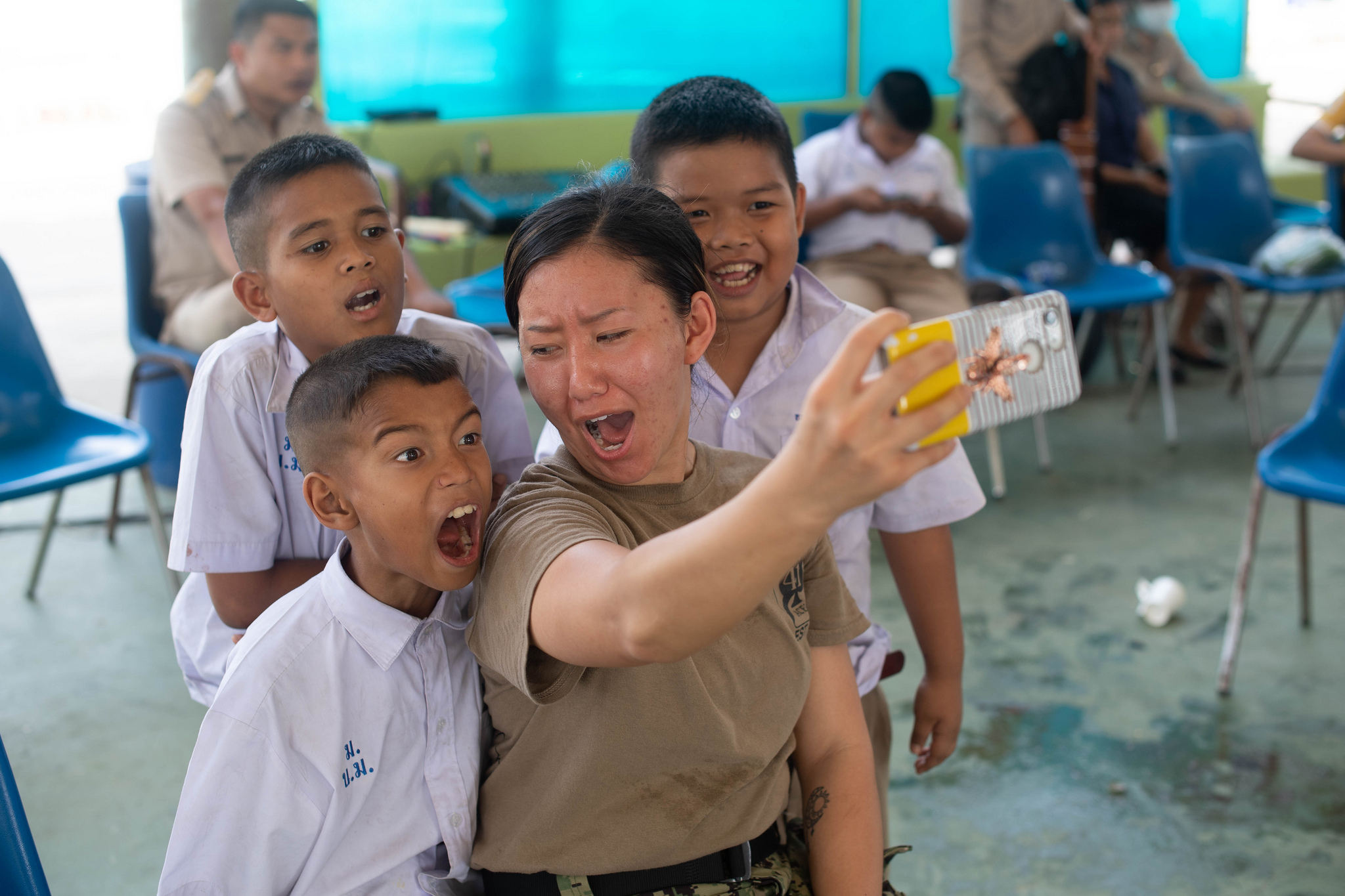 Navy Aviation Machinist’s Mate 2nd Class Txi Txi Mee Lee, from Oshkosh, Wis., poses for a selfie with children Feb. 11, 2019, during a community outreach event at the Ban Banglamung School in in Laem Chabang, Thailand. Sailors assigned to the John C. Stennis Carrier Strike Group volunteered at the Ban Banglamung School during a scheduled port visit to Laem Chabang. (Mass Communication Specialist 3rd Class Grant G. Grady/Navy)