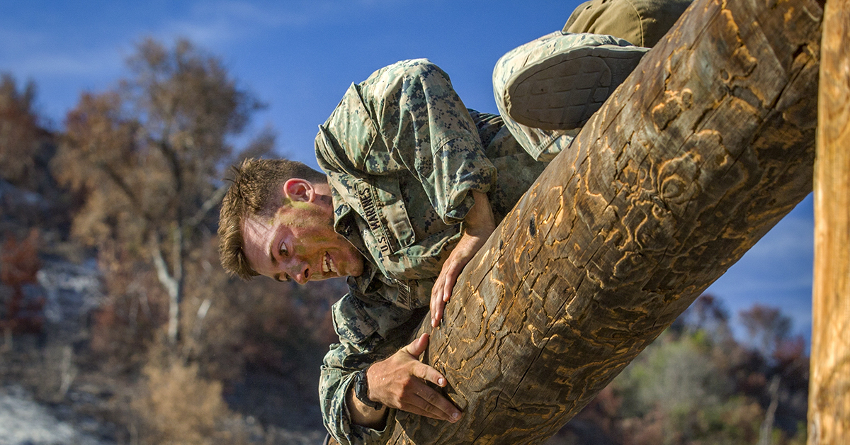 Marine Corps Lance Cpl. John Marino, a machine gunner with 1st Marine Regiment, climbs over a log during the obstacle course portion of the 1st Marine Division (MARDIV) Super Squad Competition at Marine Corps Base Camp Pendleton, California, Aug. 30, 2018. (Lance Cpl. Audrey M.C. Rampton/Marine Corps)