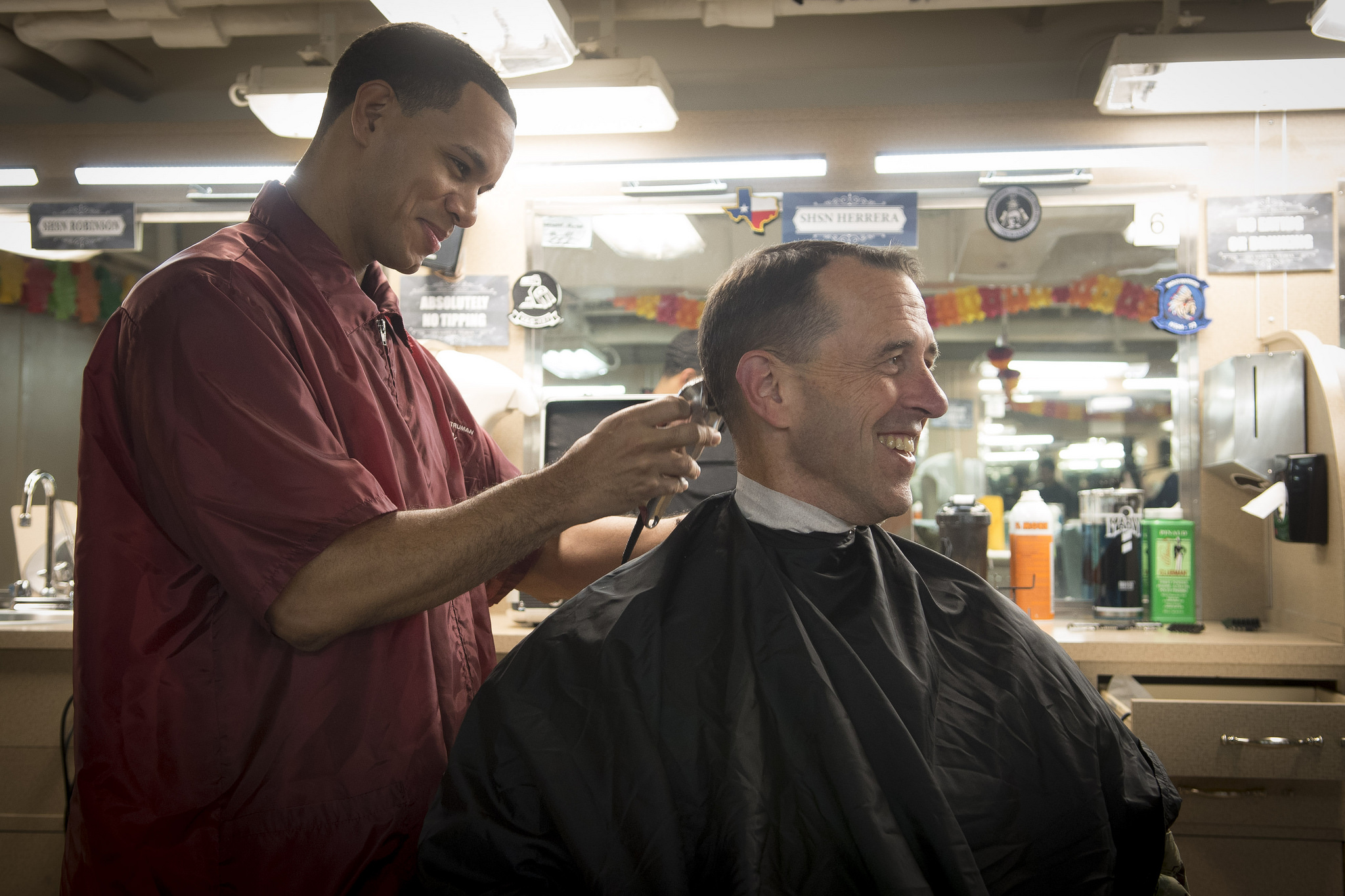 Ship's Serviceman 3rd Class Pedro Solis-Perez gives a haircut to Chief of Naval Operations Adm. John Richardson aboard the Nimitz-class aircraft carrier USS Harry S. Truman (CVN 75) on Nov. 23, 2018, in the Mediterranean Sea. Richardson and Master Chief Petty Officer of the Navy Russell Smith visited the ship to collect feedback and express their gratitude for the crew’s warfighting readiness. (MC1 Sarah Villegas/Navy)