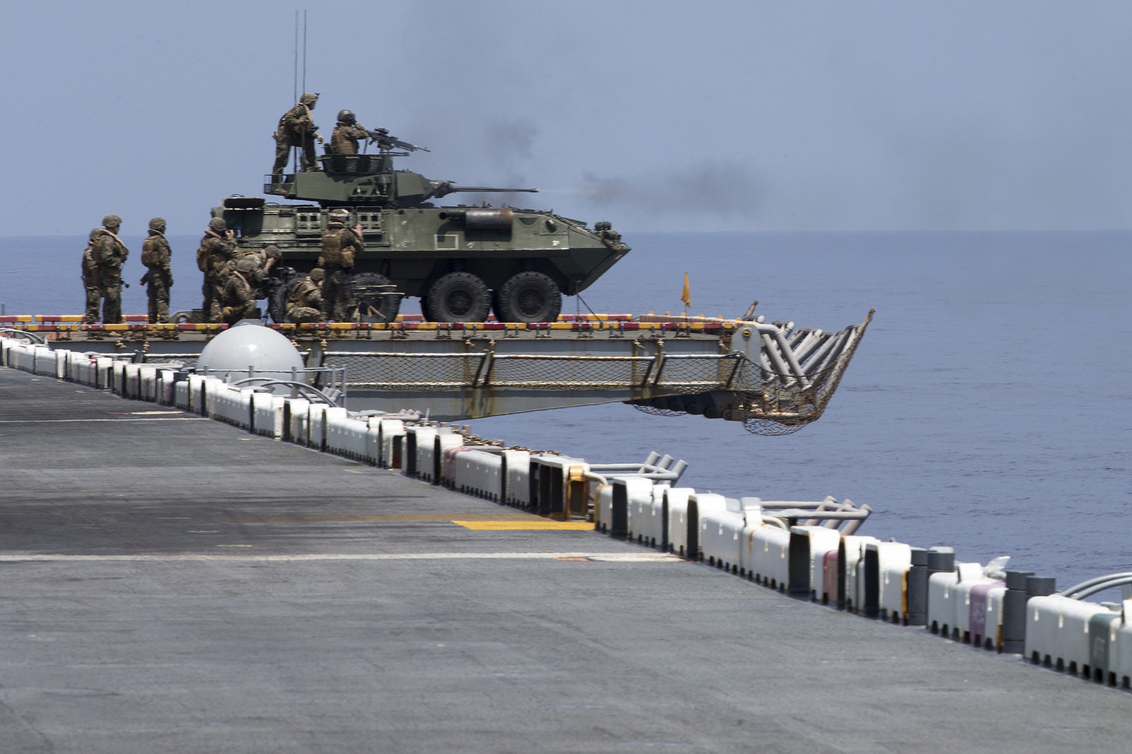 Marines with Weapons Company, Battalion Landing Team, 2nd Battalion, 5th Marines, sit on a Light Armored Vehicle atop the flight deck aboard the amphibious assault ship USS Wasp (LHD 1) on Sept. 27, 2018, during a defense of the amphibious task force drill in the South China Sea. During the training, Marines with BLT 2/5 and crewmen with the Wasp rehearsed ship security using a variety of mounted and dismounted small-arms and heavy weapons. (Gunnery Sgt. E. V. Hagewood/Marine Corps)